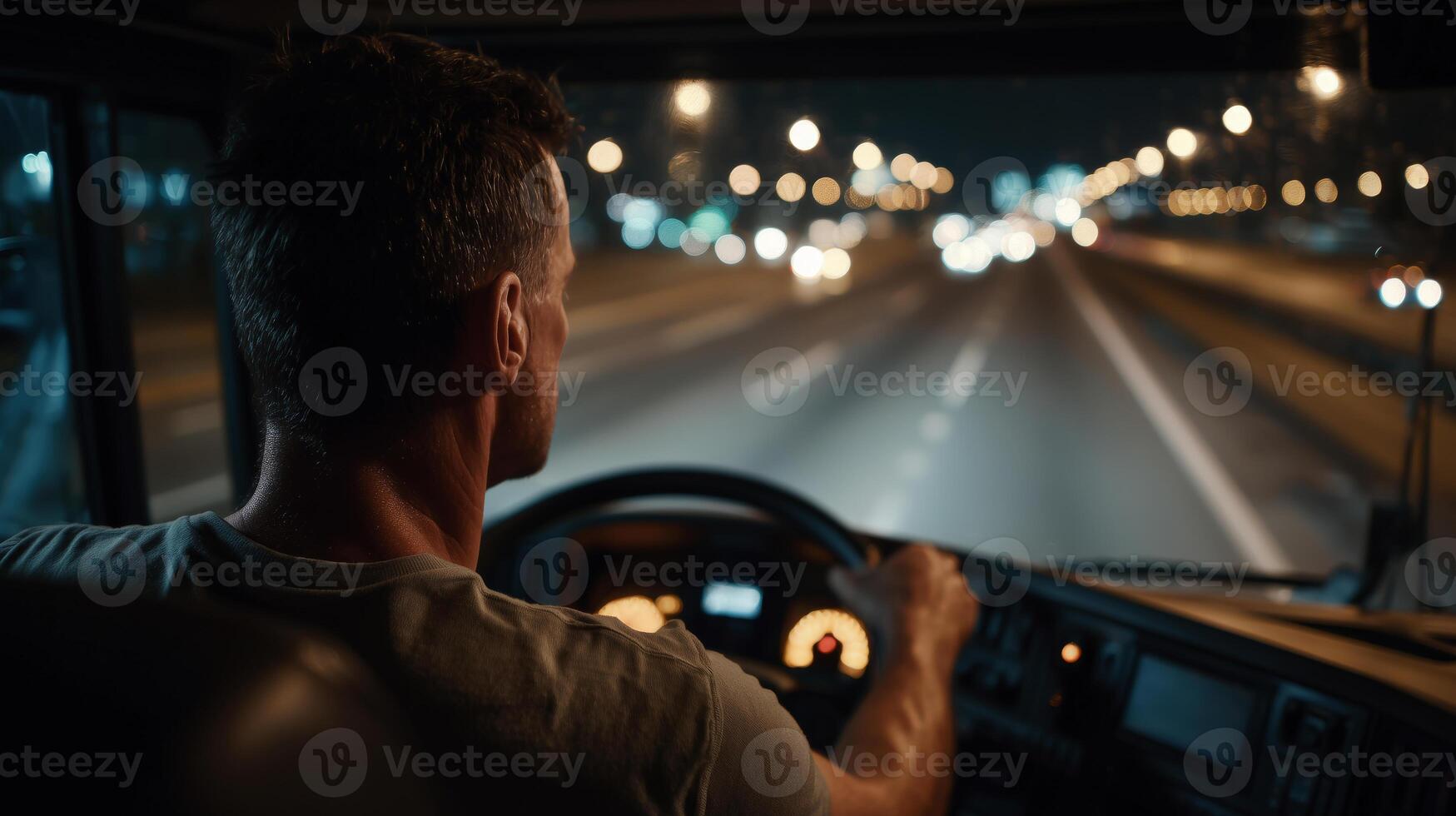 A truck driver focuses intently on the road ahead during a night journey. The illuminated highway stretches out with blurring lights, reflecting the challenges of long-distance driving. photo