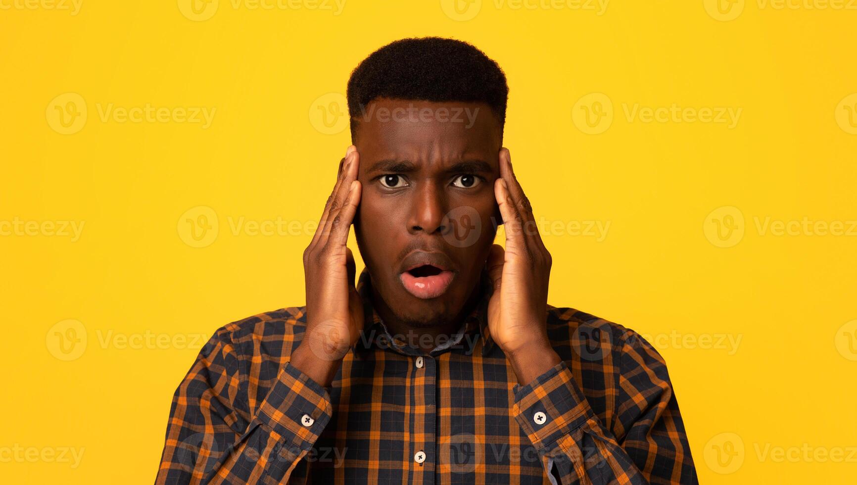 Oh No. Confused African American Guy Touching Head And Looking At Camera, Frustrated Black Millennial Man Emotionally Reacting To News, Standing Isolated On Yellow Studio Background, Copy Space photo