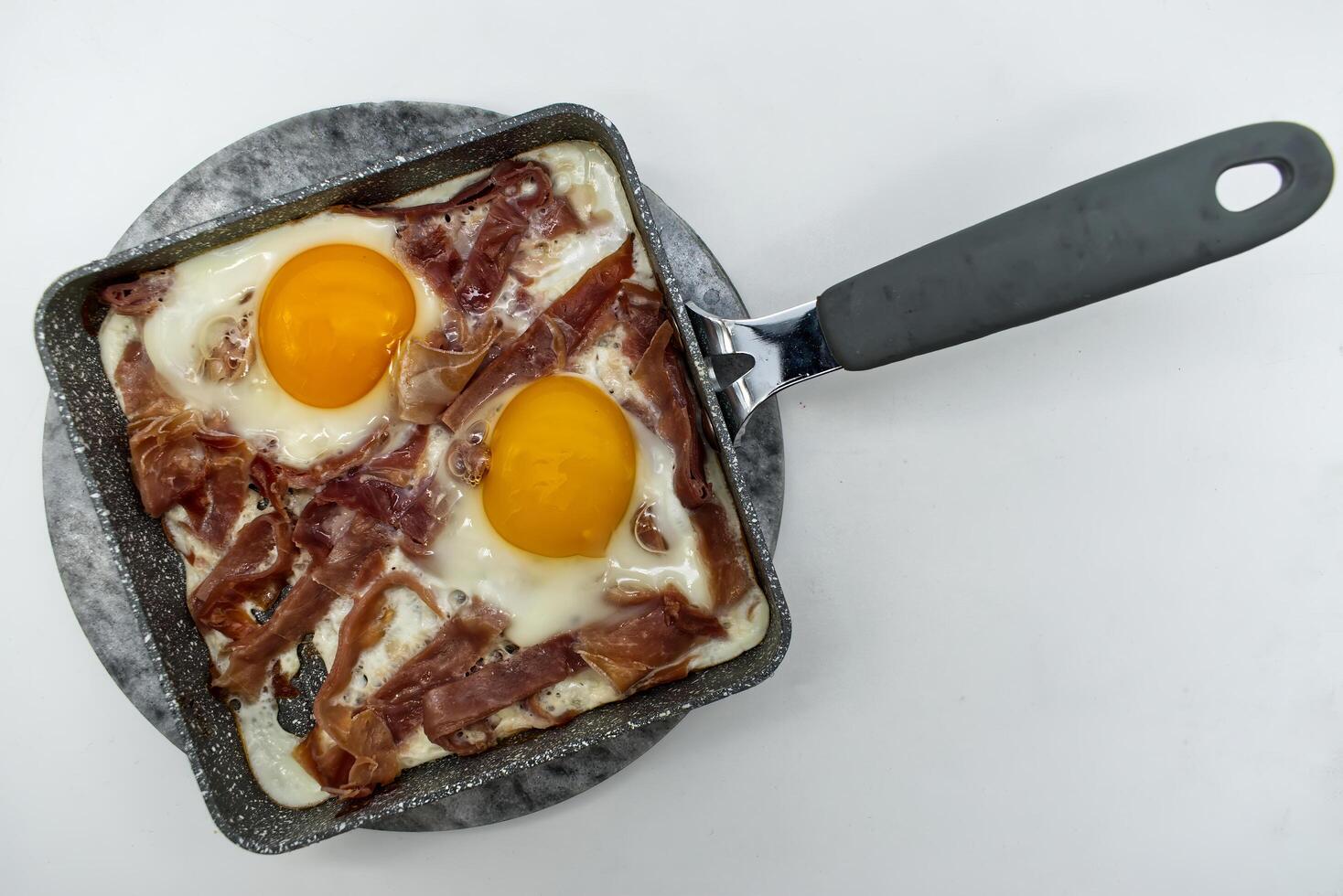 Delicious Fried Eggs with Prosciutto in a Square Pan photo