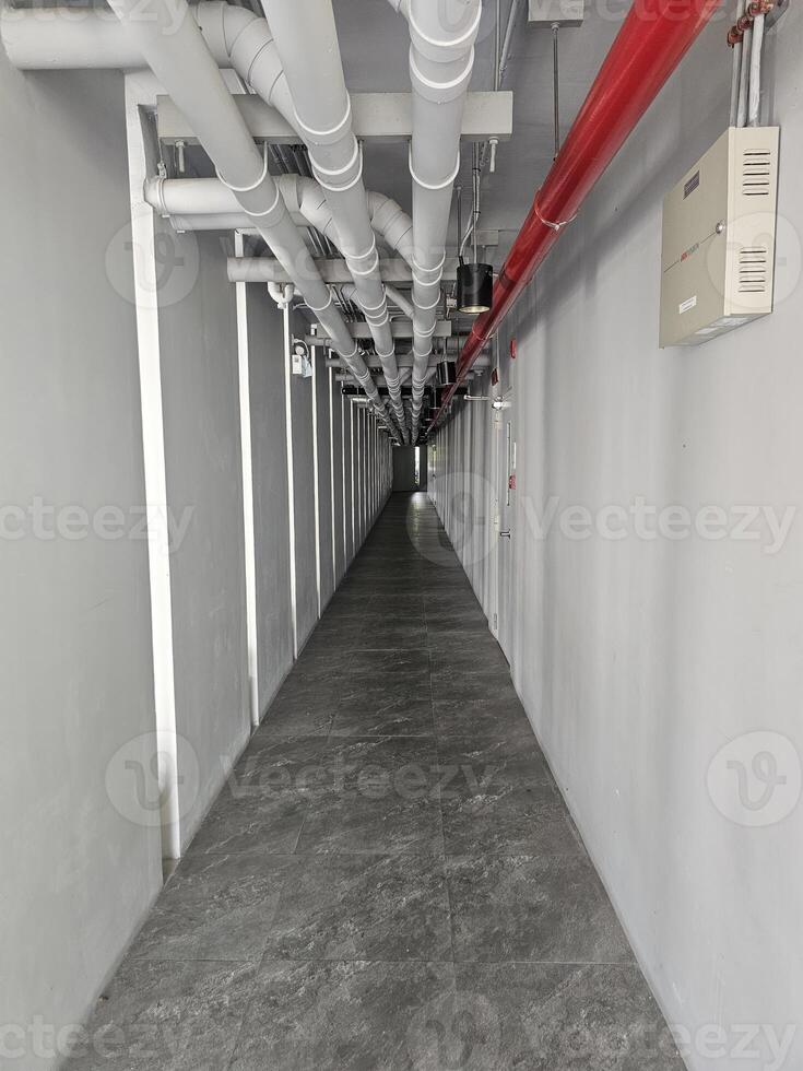 Industrial Pipework and Modern Flooring in a Long Corridor Space photo