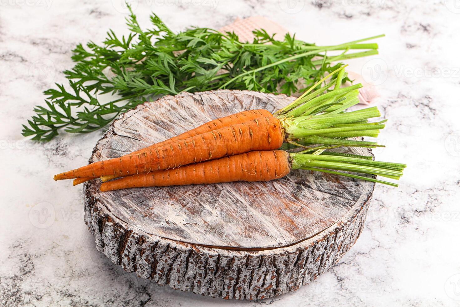Two carrots on a wooden stump photo