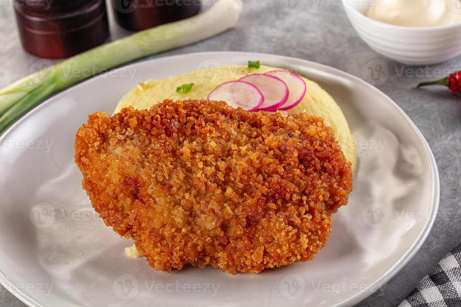 Fried chicken cutlet with mashed potatoes and pickles on a plate photo