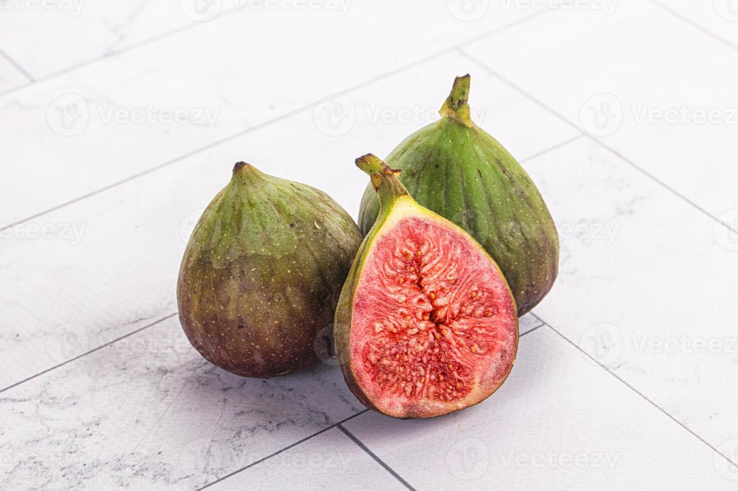 Three figs on a white tile floor photo