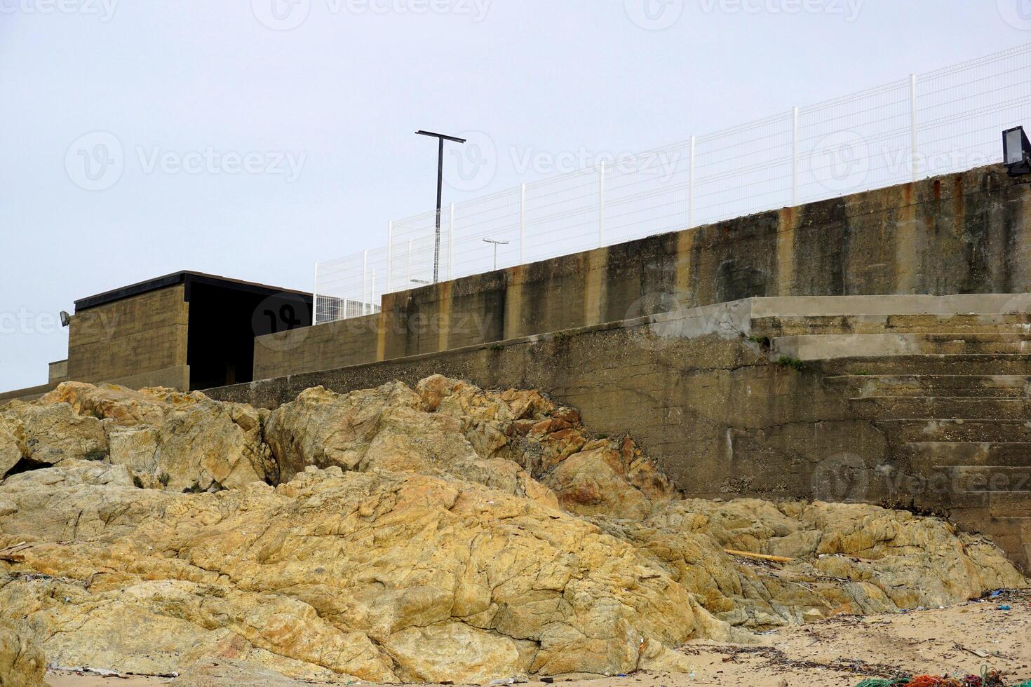 Coastal concrete structure and rock formations at the beach landscape scenery photo