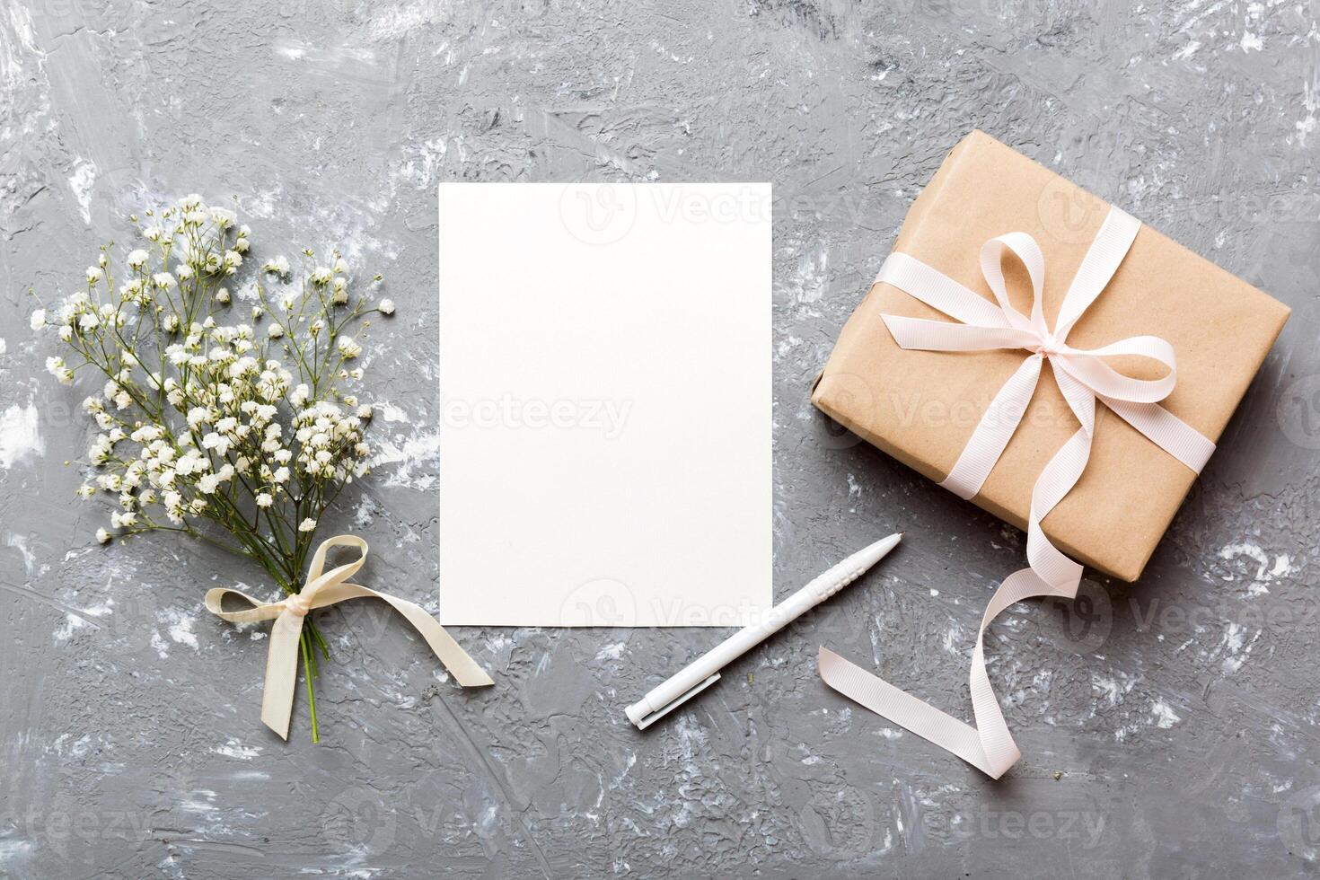 Wedding mockup white paper list and flowers gypsophila on colored table top view flat lay. Blank greeting cards and envelopes. Beautiful floral pattern photo