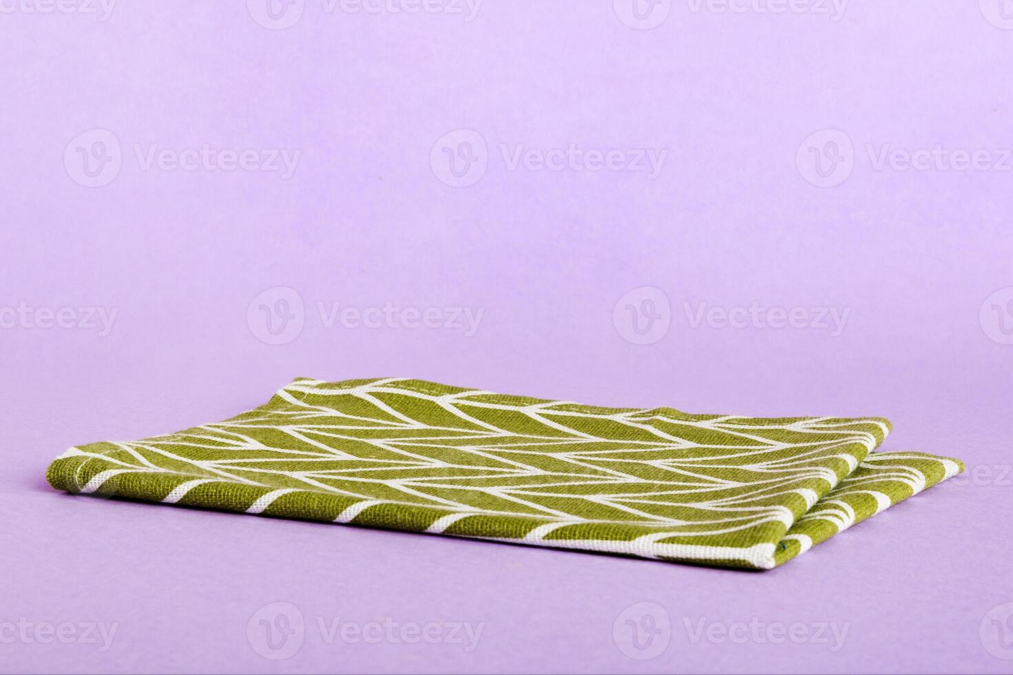 top view green kitchen napkin isolated on table background. Folded cloth for mockup with copy space photo