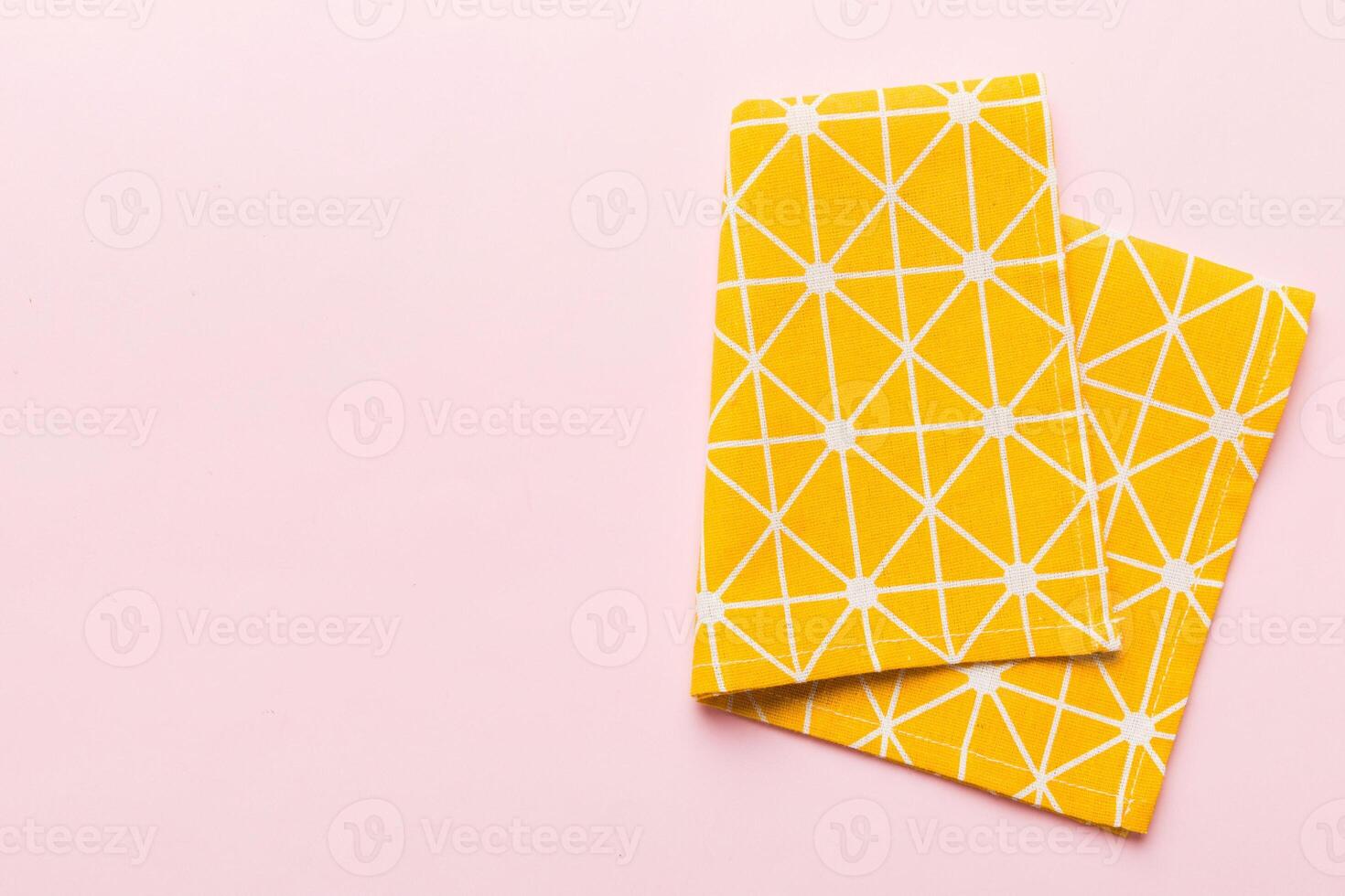 top view with yellow empty kitchen napkin isolated on table background. Folded cloth with copy space photo