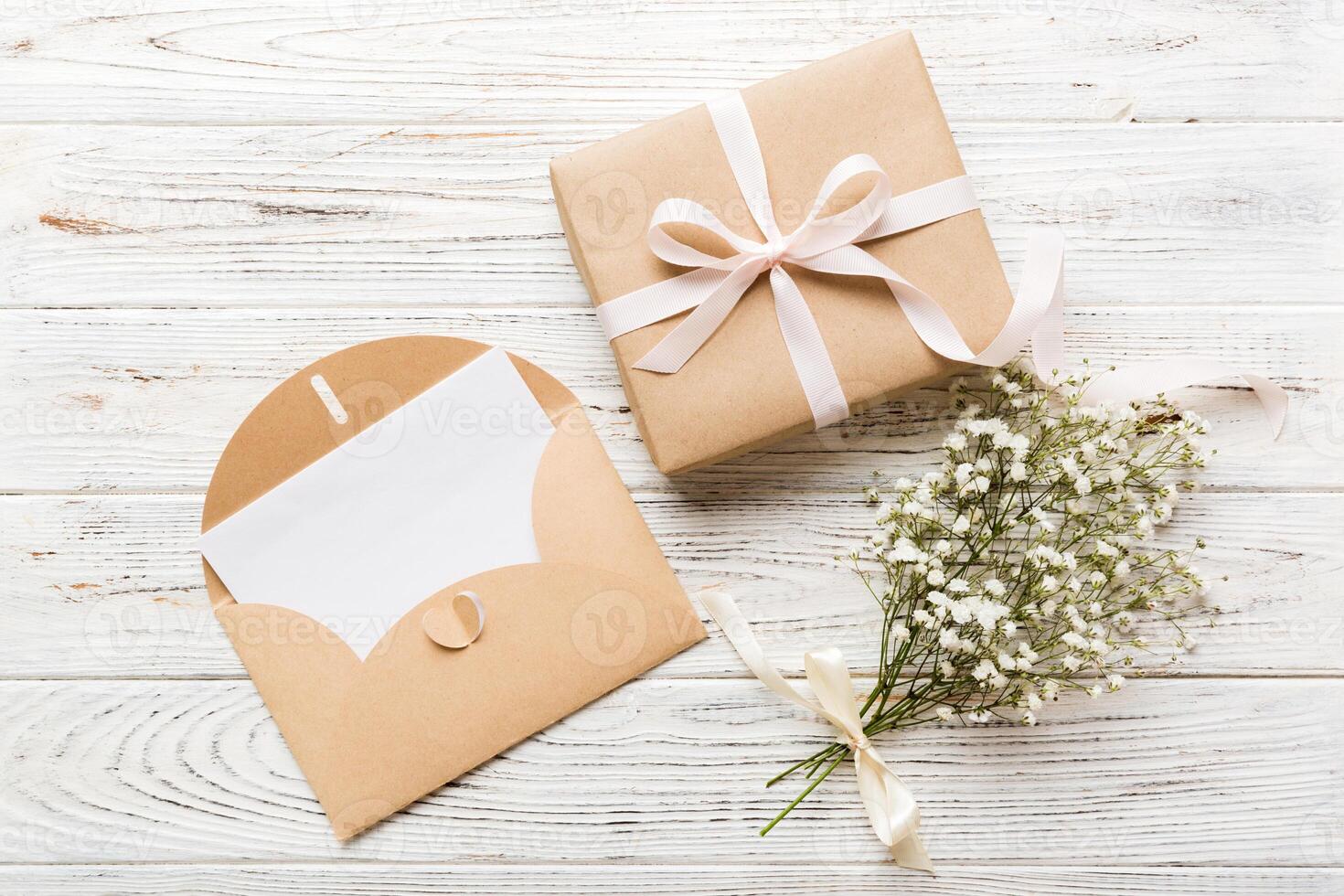 Wedding mockup white paper list and flowers gypsophila on colored table top view flat lay. Blank greeting cards and envelopes. Beautiful pattern. photo