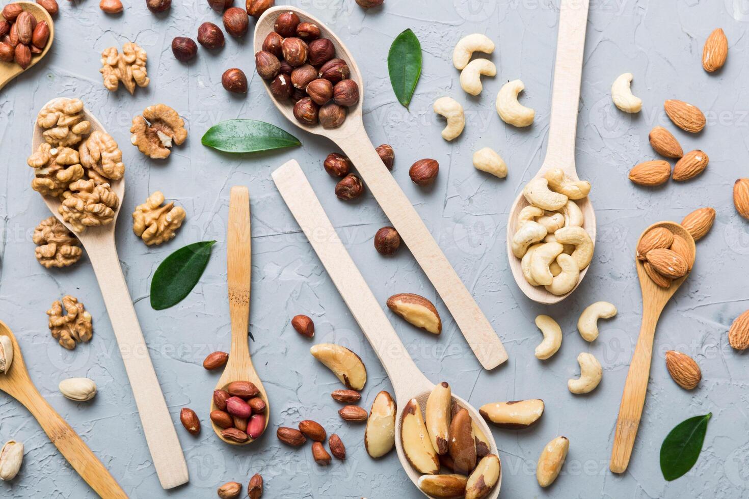 mixed nuts white wooden spoon. Mix various nuts on colored background. pistachios, cashews, walnuts, peanuts and brazil nuts photo