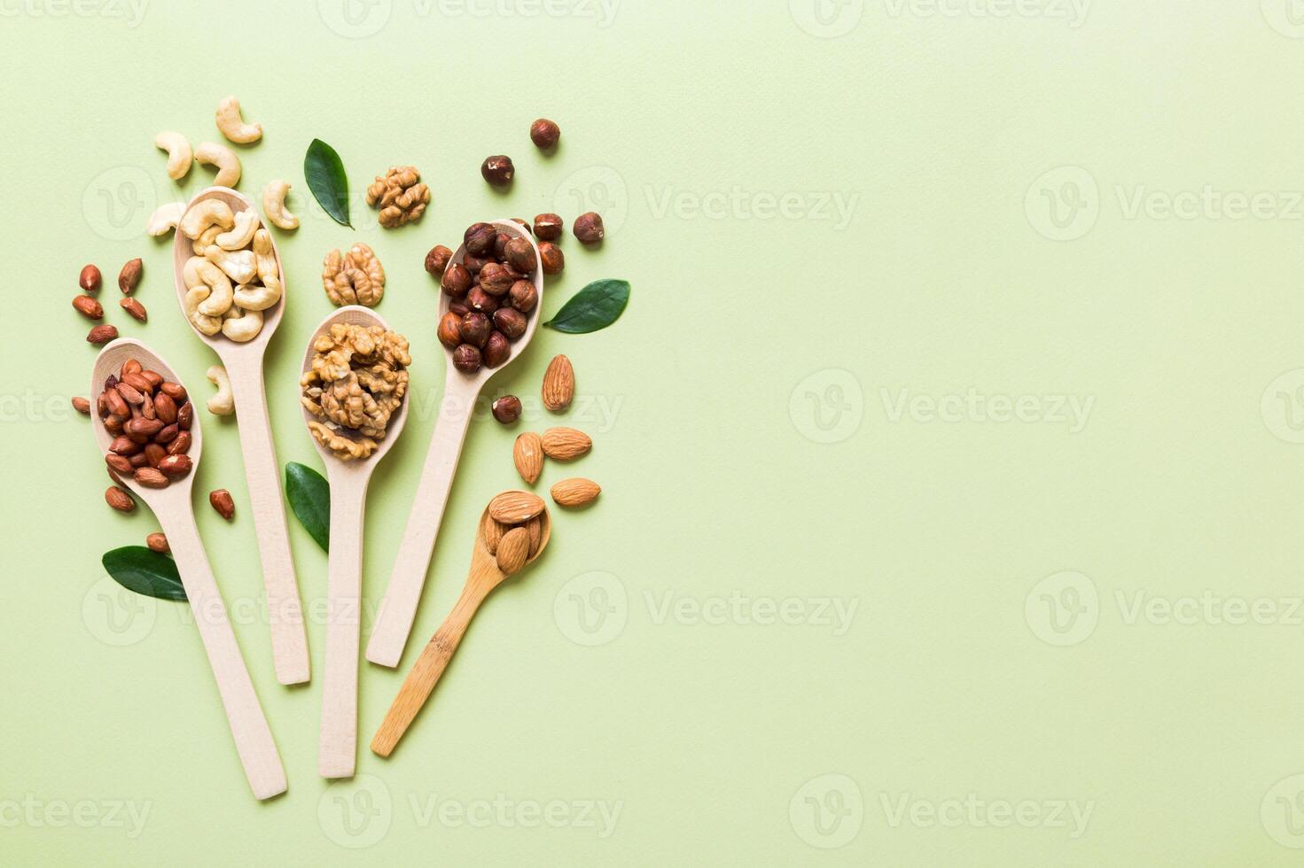 mixed nuts white wooden spoon. Mix of various nuts on colored background. pistachios, cashews, walnuts, peanuts and brazil nuts photo