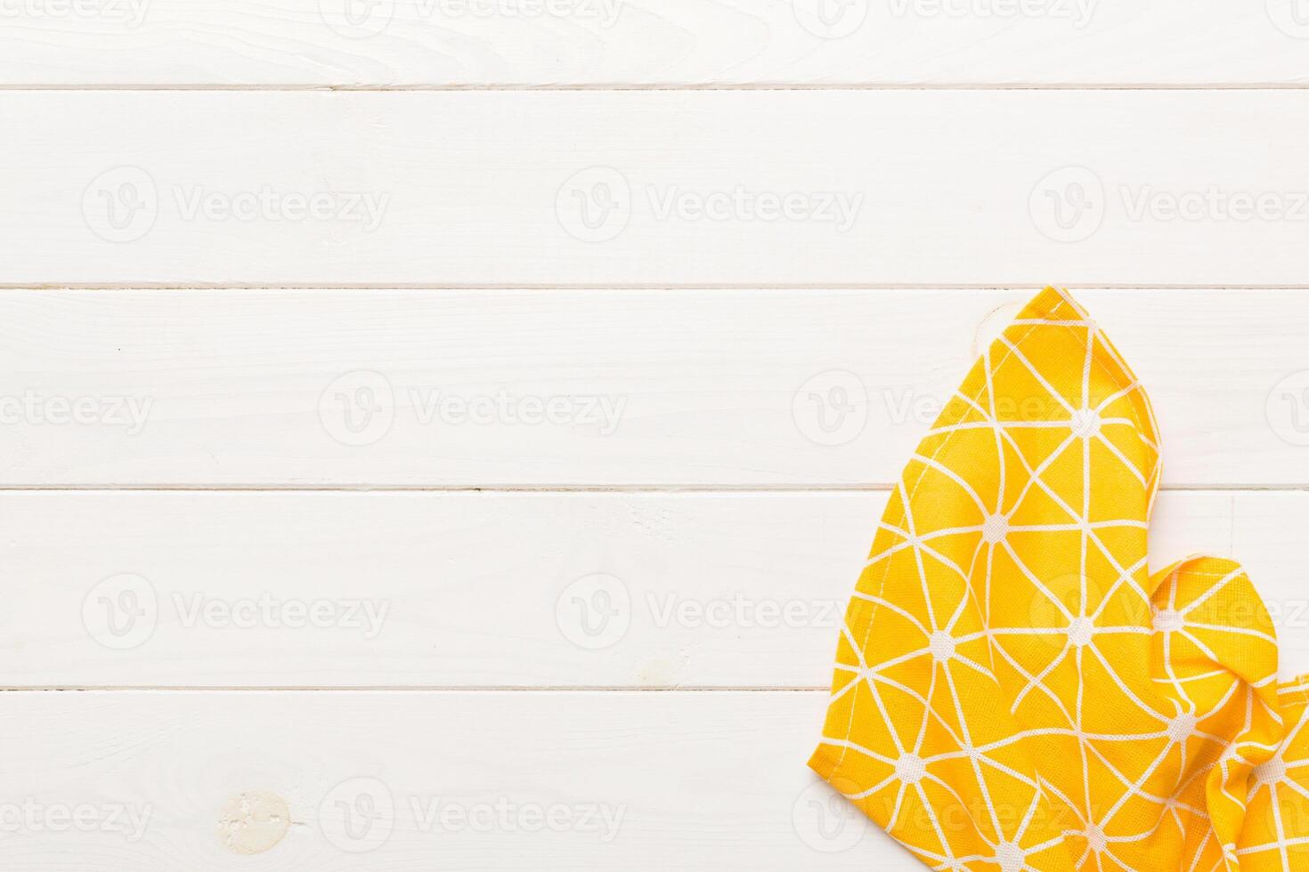 top view with yellow empty kitchen napkin isolated on table background. Folded cloth photo