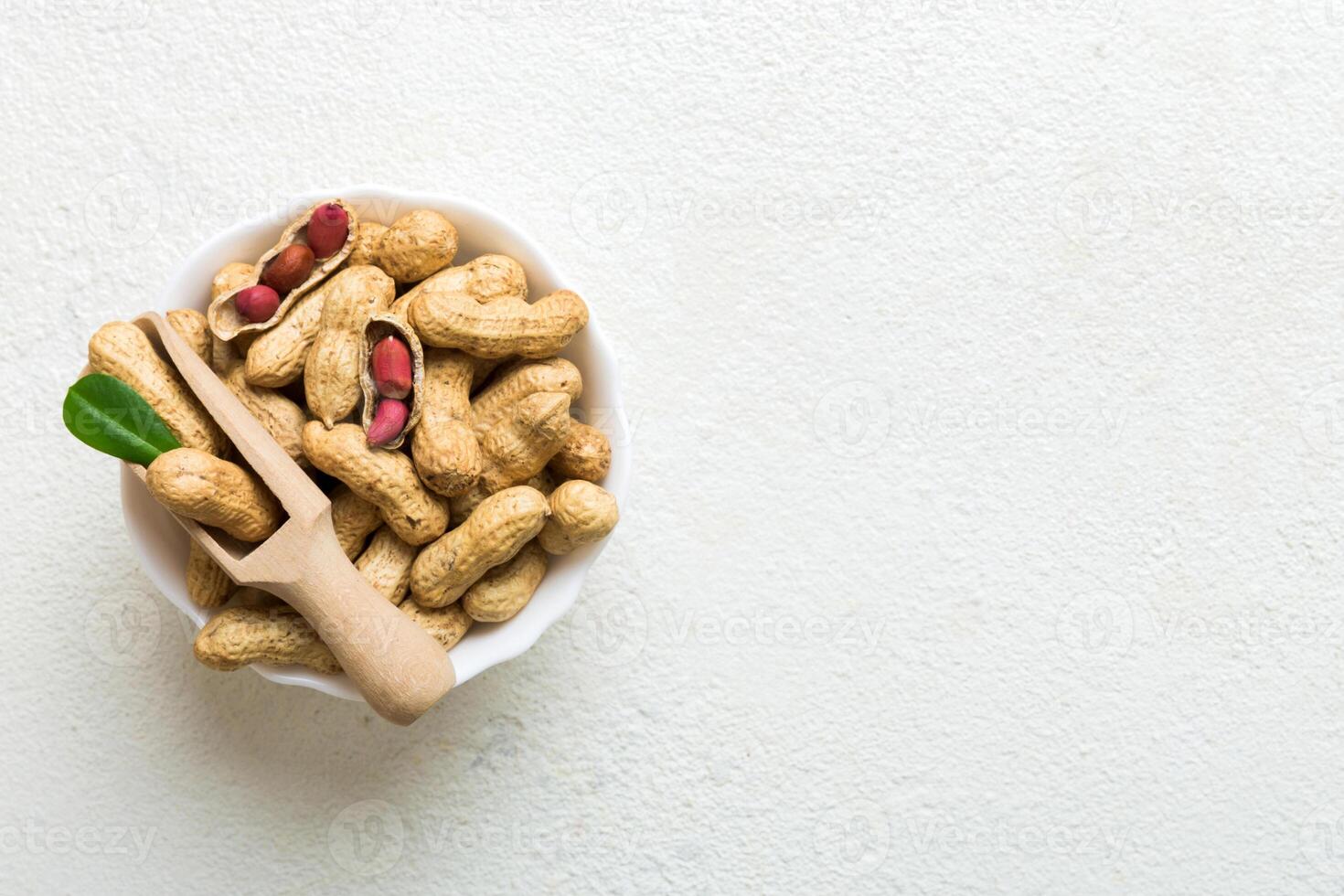 Fresh healthy peanuts in bowl on colored table background. Top view Healthy eating bertholletia concept photo