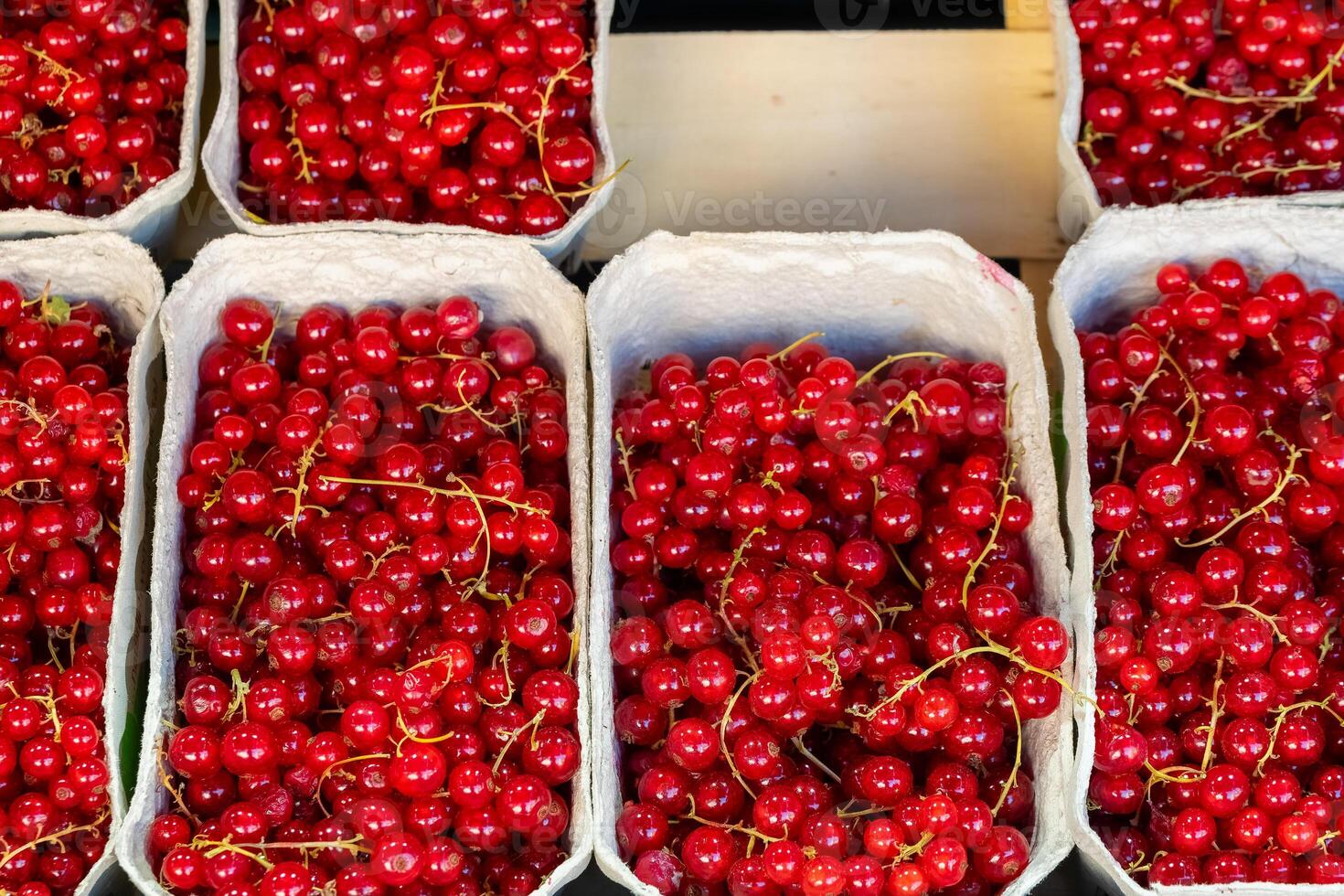 Freshly harvested red currants displayed at an open-air market during the vibrant summer season photo