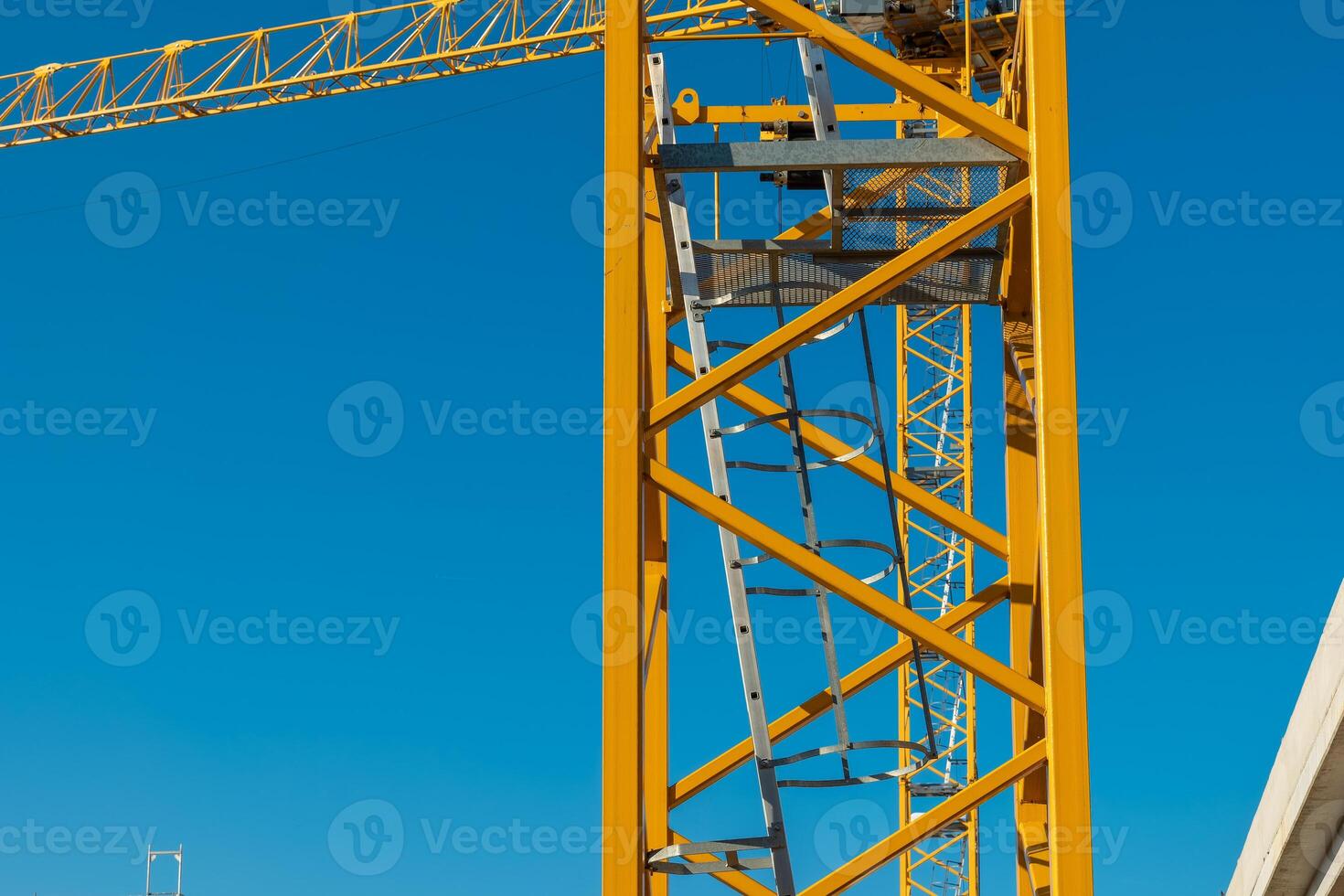 Construction tower crane stands tall against a clear blue sky, showcasing intricate details of industrial architecture and engineering photo