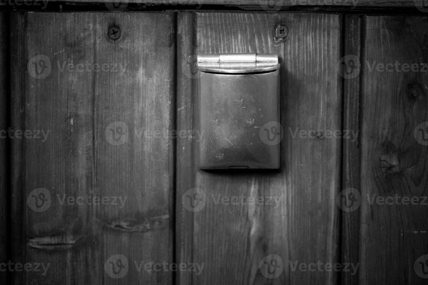 Rustic mail slot set in an aged wooden door, capturing the charm of a vintage entryway in a quaint village photo