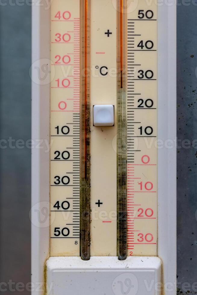 Temperature gauge provides a clear view of the outdoor conditions on a bright sunny day, reflecting varying degrees from freezing to hot photo