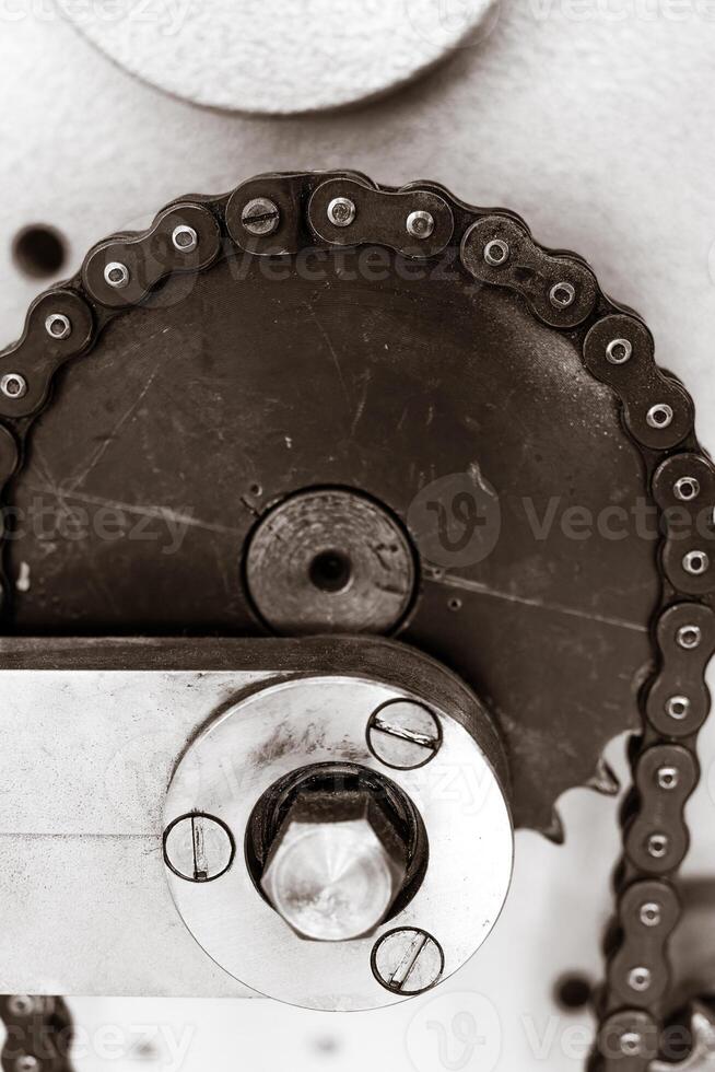 Gears and chains interact in a mechanical dance in an industrial workshop photo