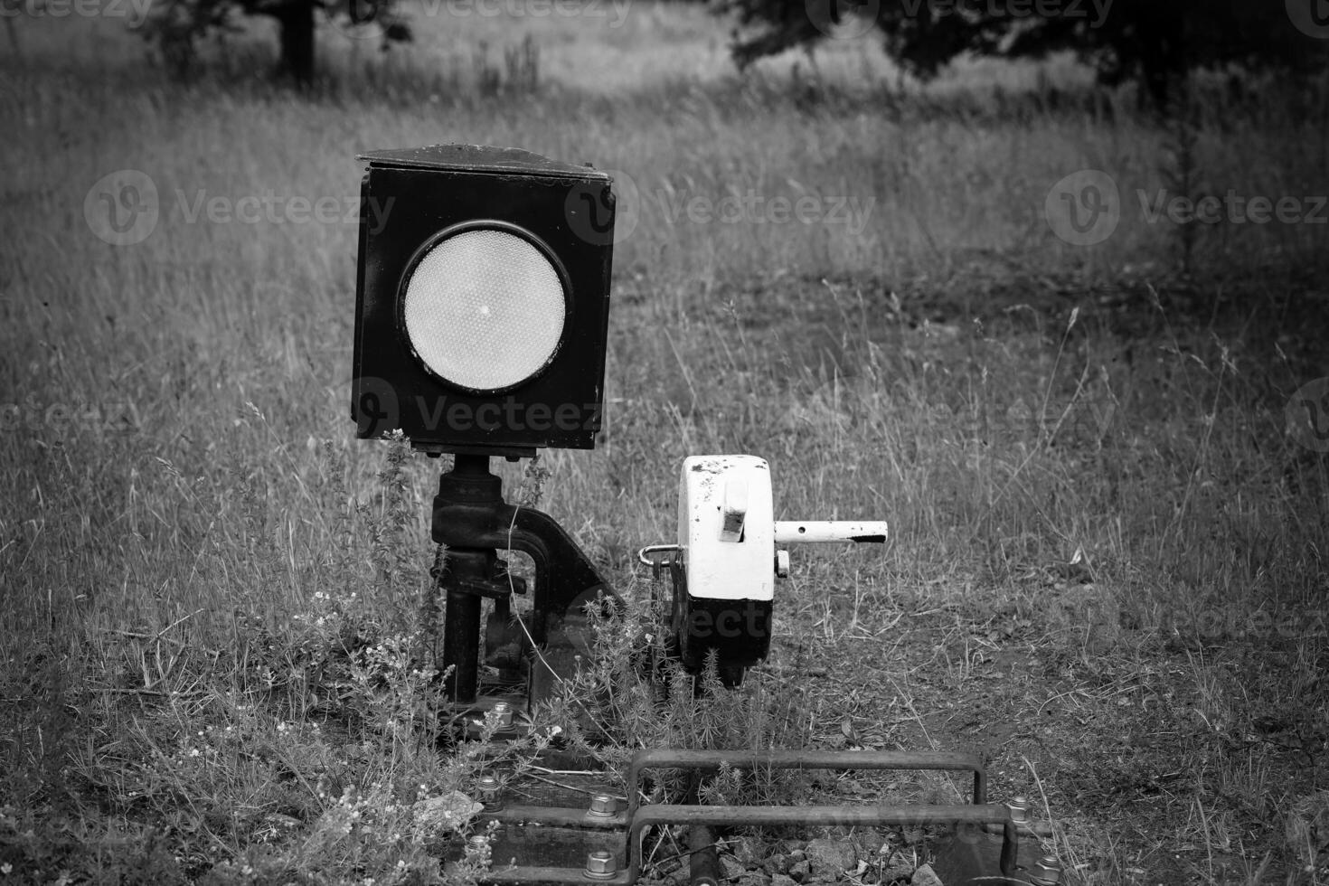 Rail signal and control lever standing alone in the overgrown grass, hinting at stories from a forgotten rail line photo