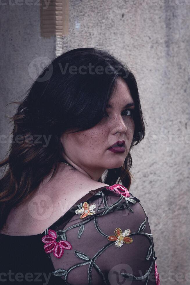 Captivating expression of beauty and elegance in an artistic urban setting at dusk with intricate floral embroidery enhancing the attire photo
