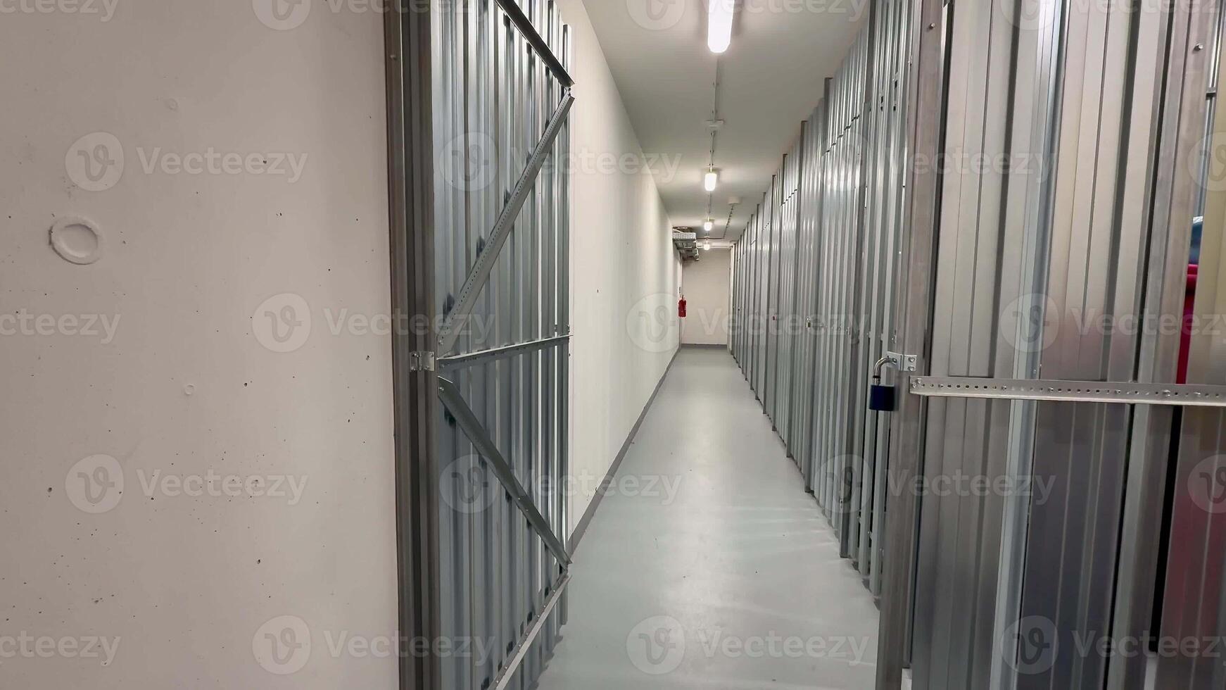 A long corridor elegantly lined with multiple secured storage units, effectively showcasing a modern storage facility photo