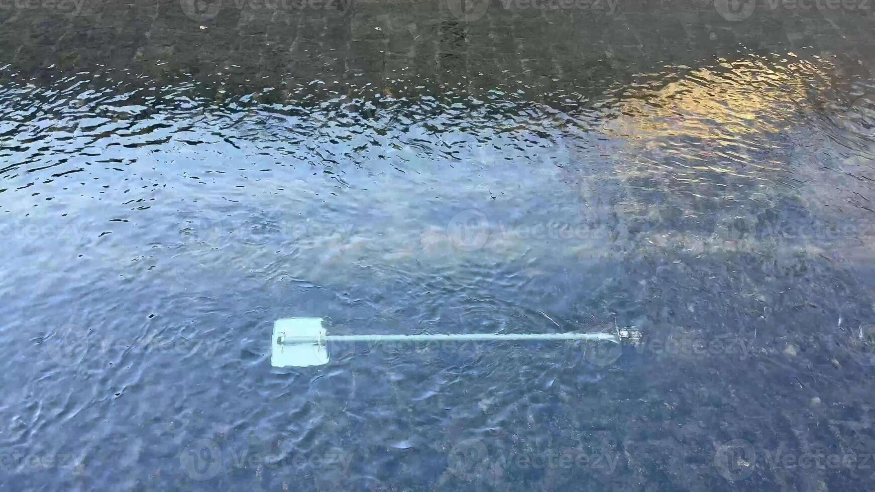 A calm and serene view of a paddle gently resting atop the still water, beautifully reflecting natures tranquility photo