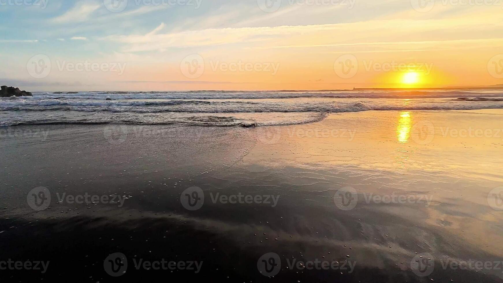 A breathtaking view of a stunning golden sunset beautifully reflecting on the tranquil ocean waves at the beach photo