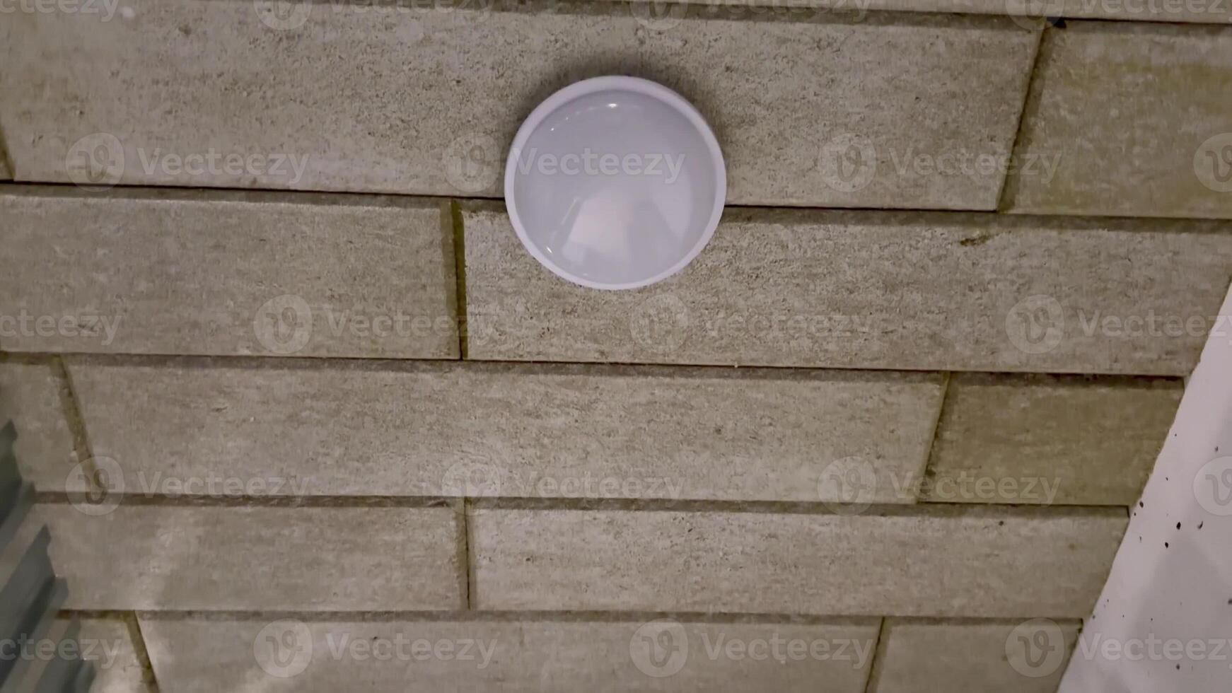 A sleek, modern ceiling light fixture beautifully mounted on a textured wall, enhancing the ambiance and style photo