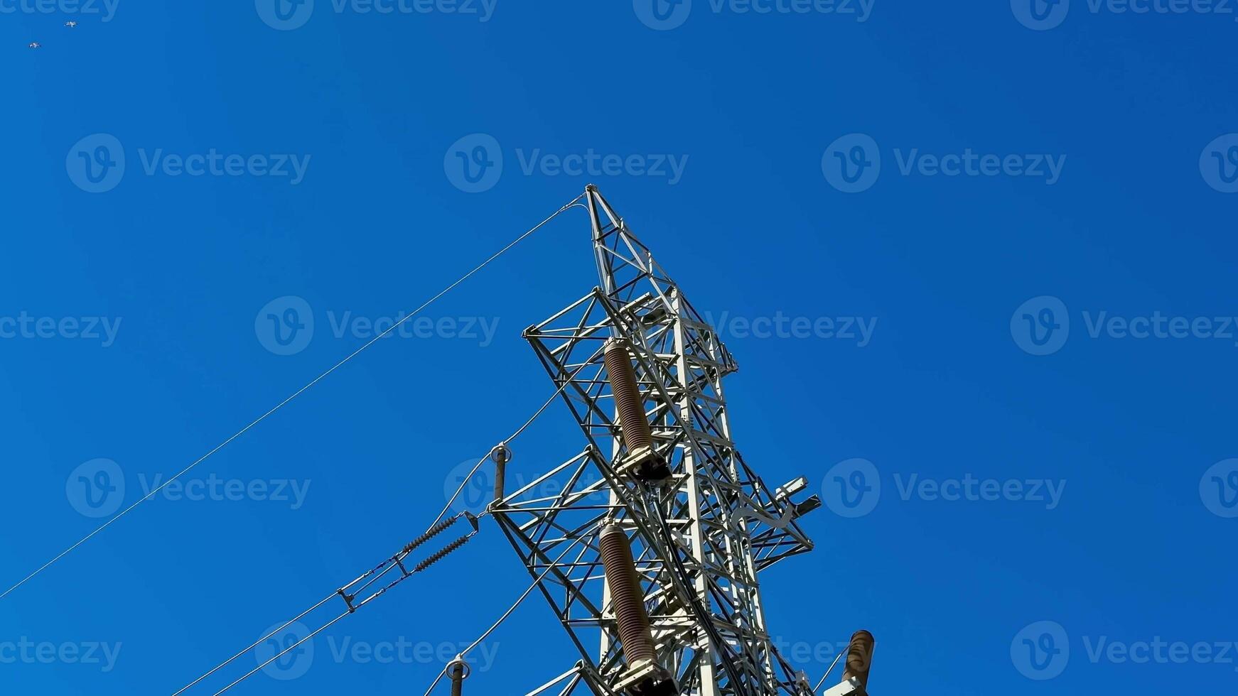 A towering structure for electrical transmission under a vibrant blue sky, showcasing engineering marvel. photo