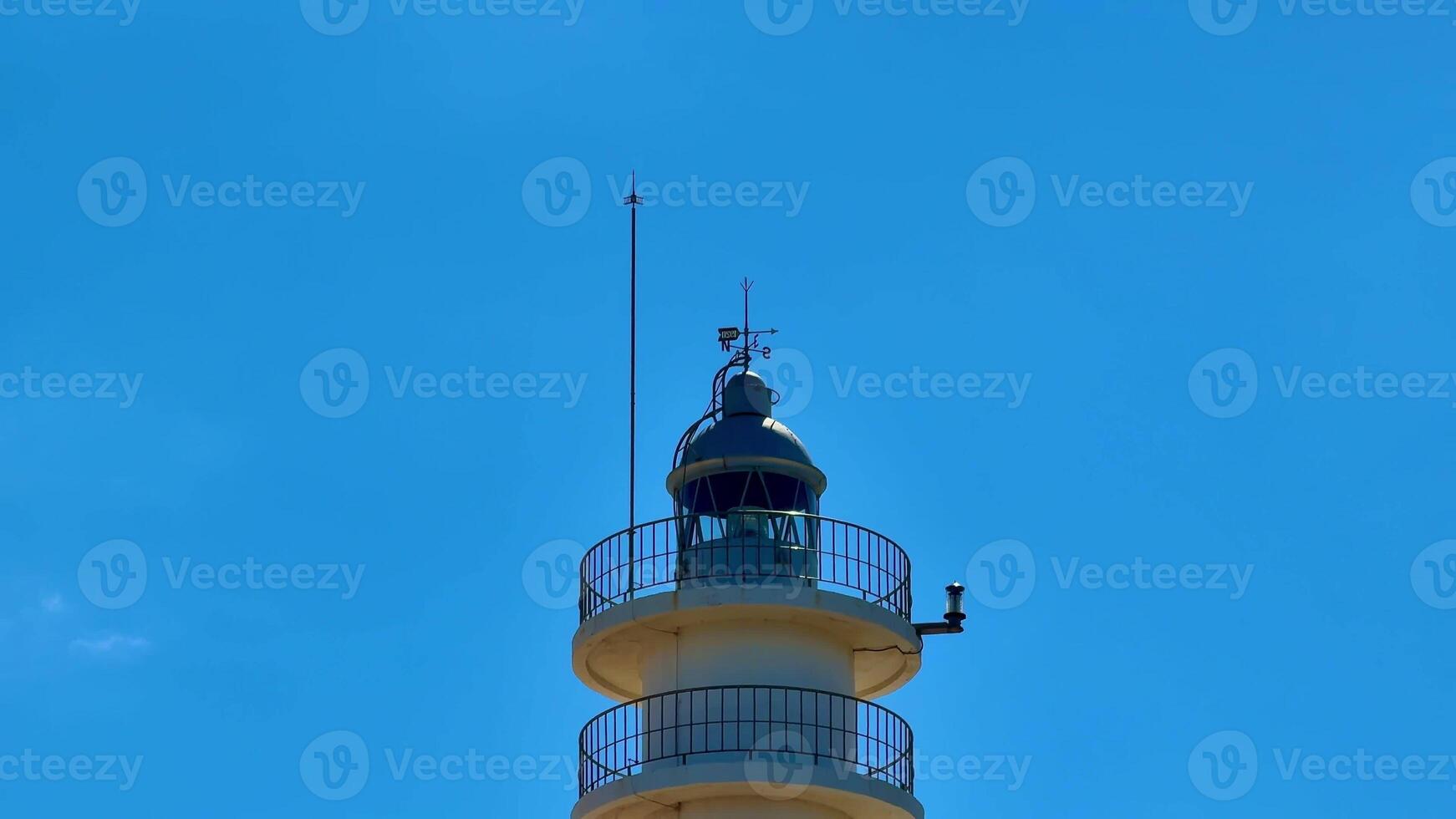 A stunning lighthouse stands tall and proud against a vibrant blue sky, symbolizing guidance and safety for all photo
