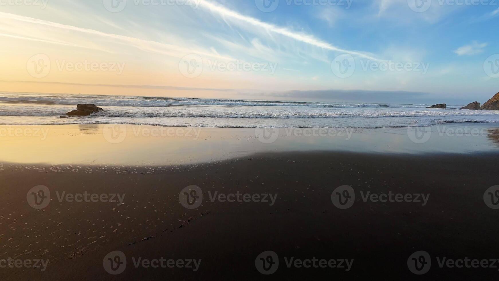 A stunningly beautiful sunset casts radiant golden hues over a tranquil and serene beach with gentle waves lapping photo