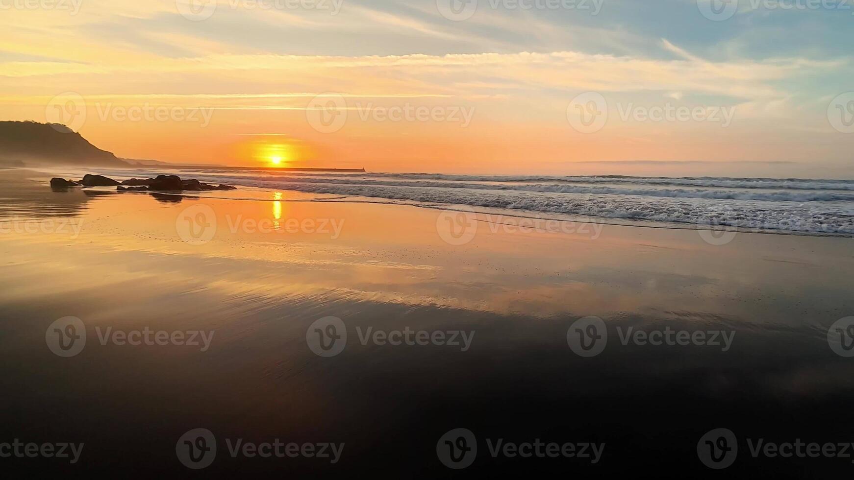 The breathtaking sunset is beautifully reflecting on the calm, tranquil ocean waters accompanied by gentle waves photo