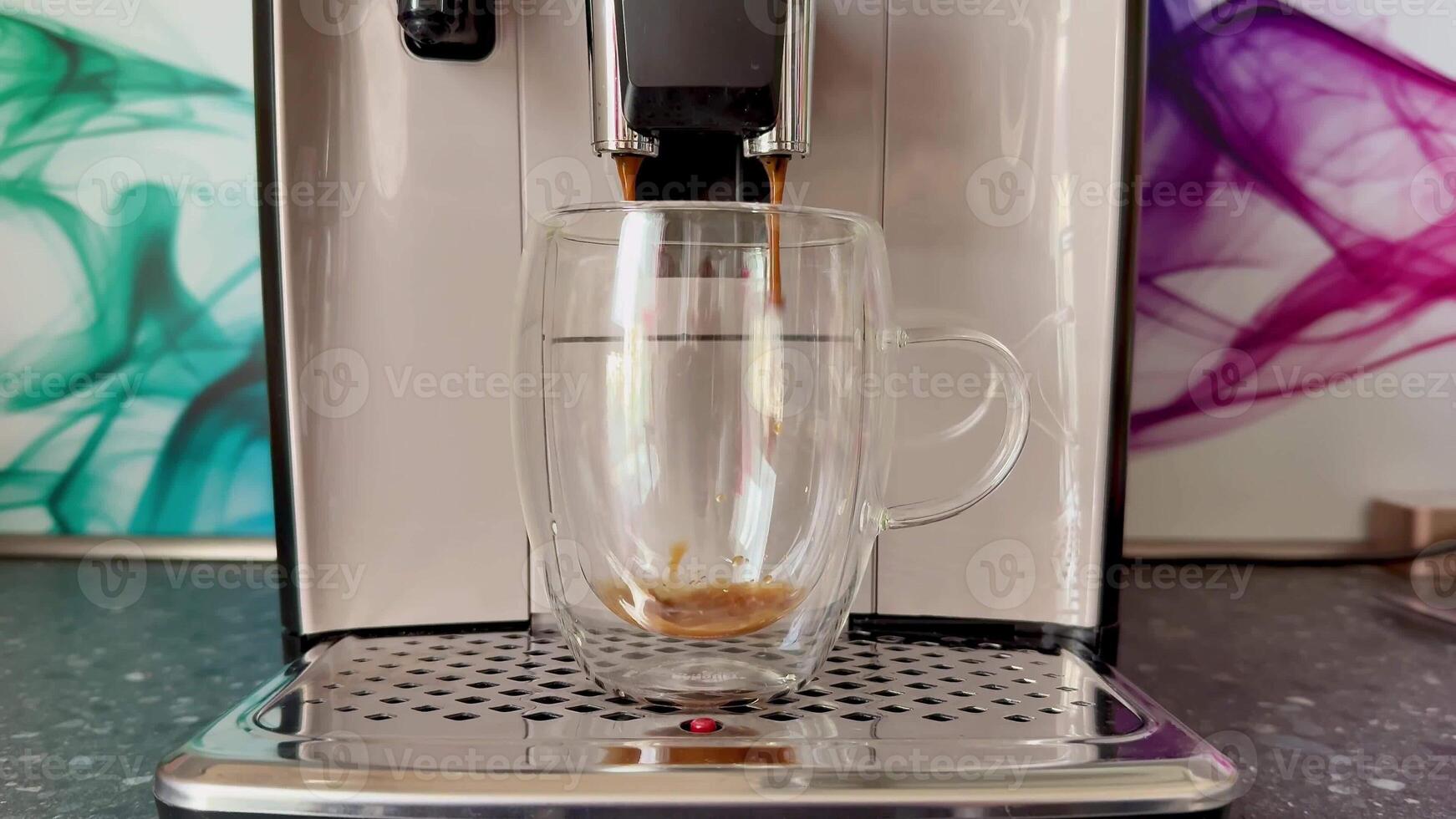 A modern coffee machine brews rich espresso in a stylish glass cup, greatly enhancing the coffee experience photo
