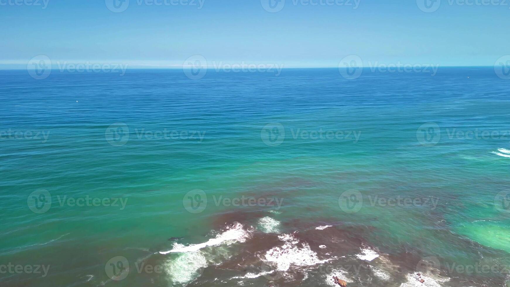 This aerial view showcases the clear blue ocean and stunning coastline, highlighting its natural beauty photo