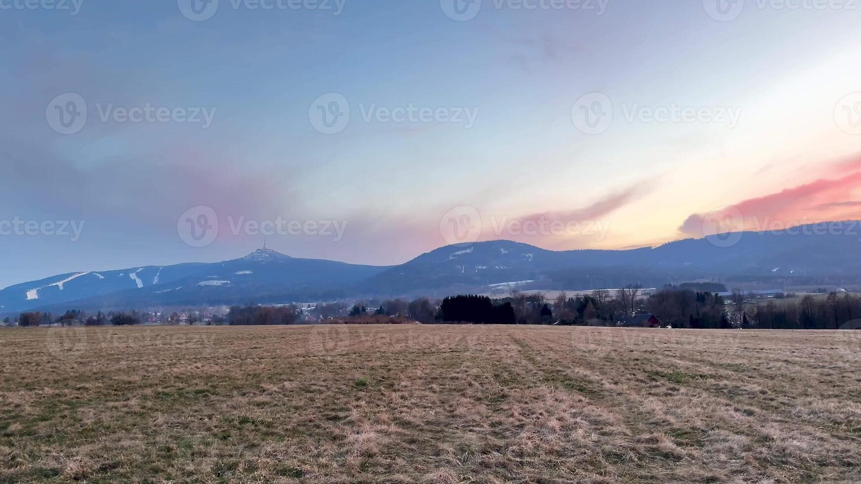 A breathtaking view of rolling hills during twilight hours, showcasing vibrant skies and expansive open fields photo