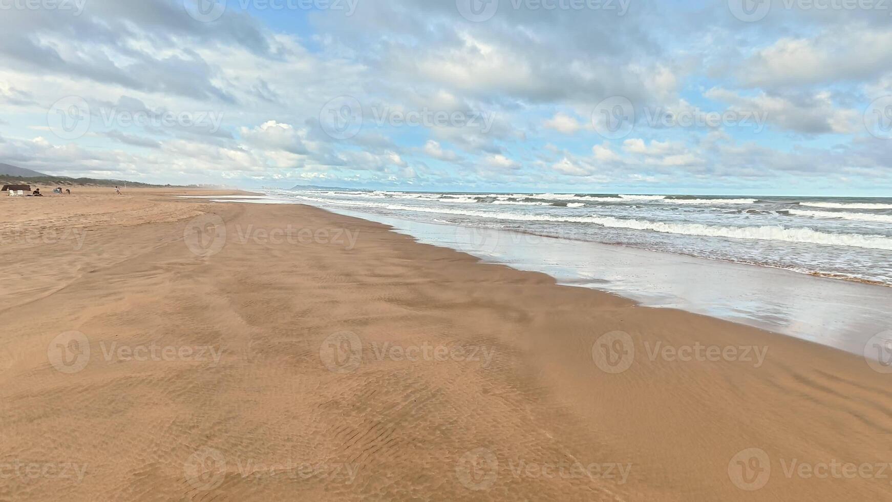 A tranquil beach view featuring soft golden sands, gentle waves rolling in, and a vibrant colorful sky above photo