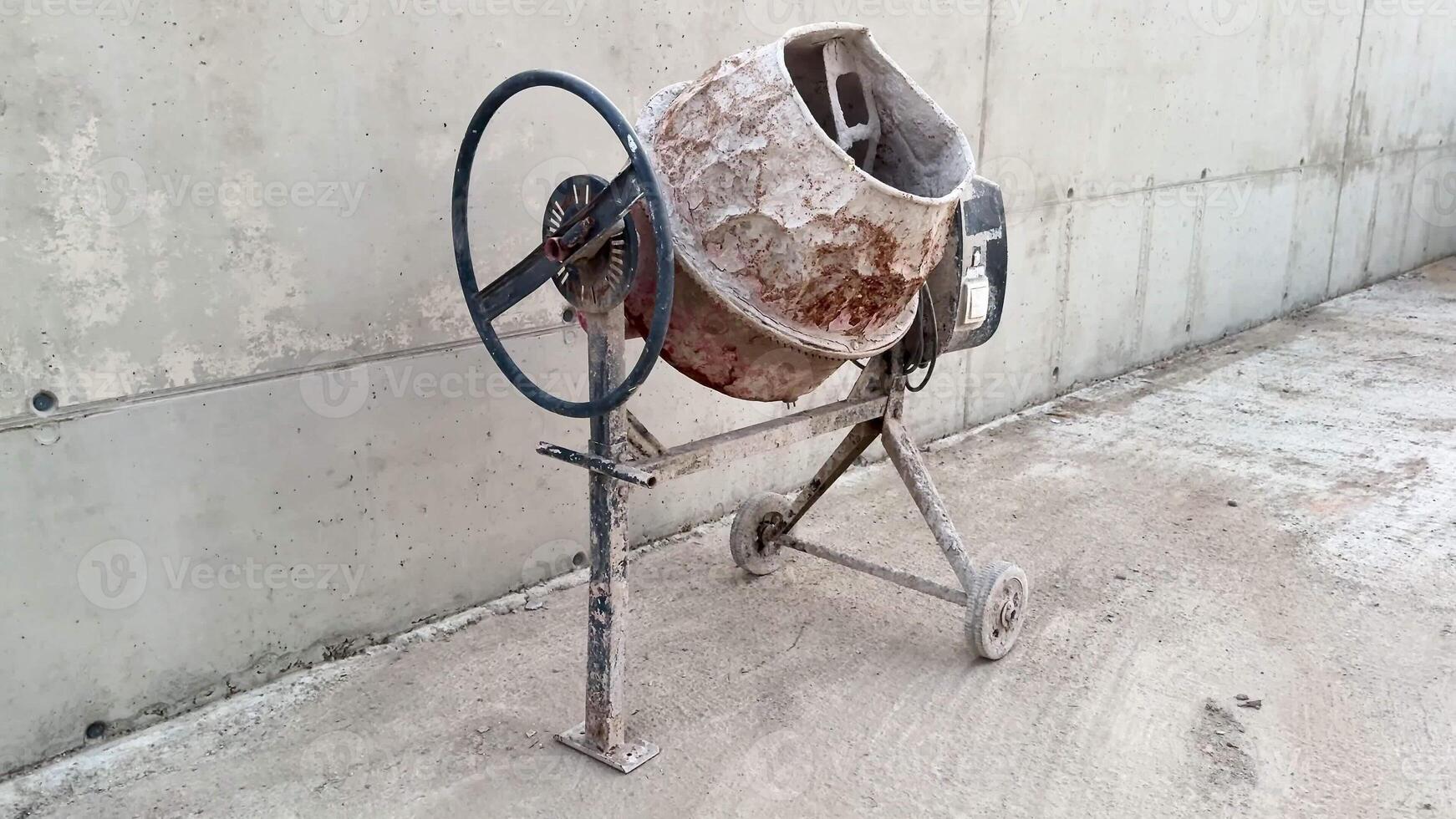 A wellused concrete mixer stands proudly at a construction site, showcasing durability and the passage of time photo
