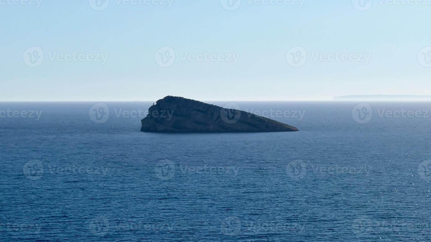 A tranquil view of the vast ocean, with a solitary rock on the horizon, illustrating natures beauty and serenity photo