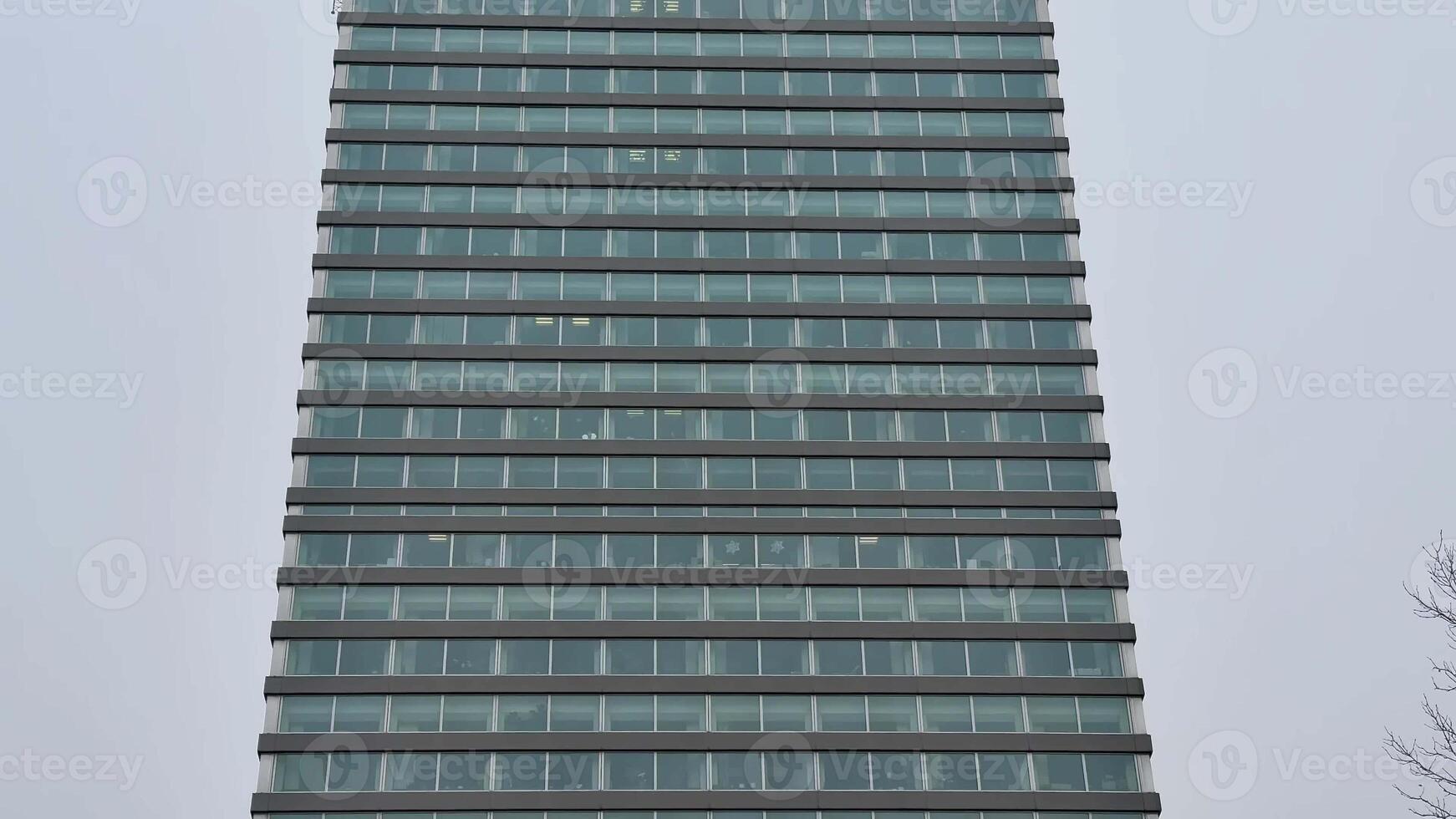 This is a sleek, modern building that showcases a striking glass facade along with unique design elements photo