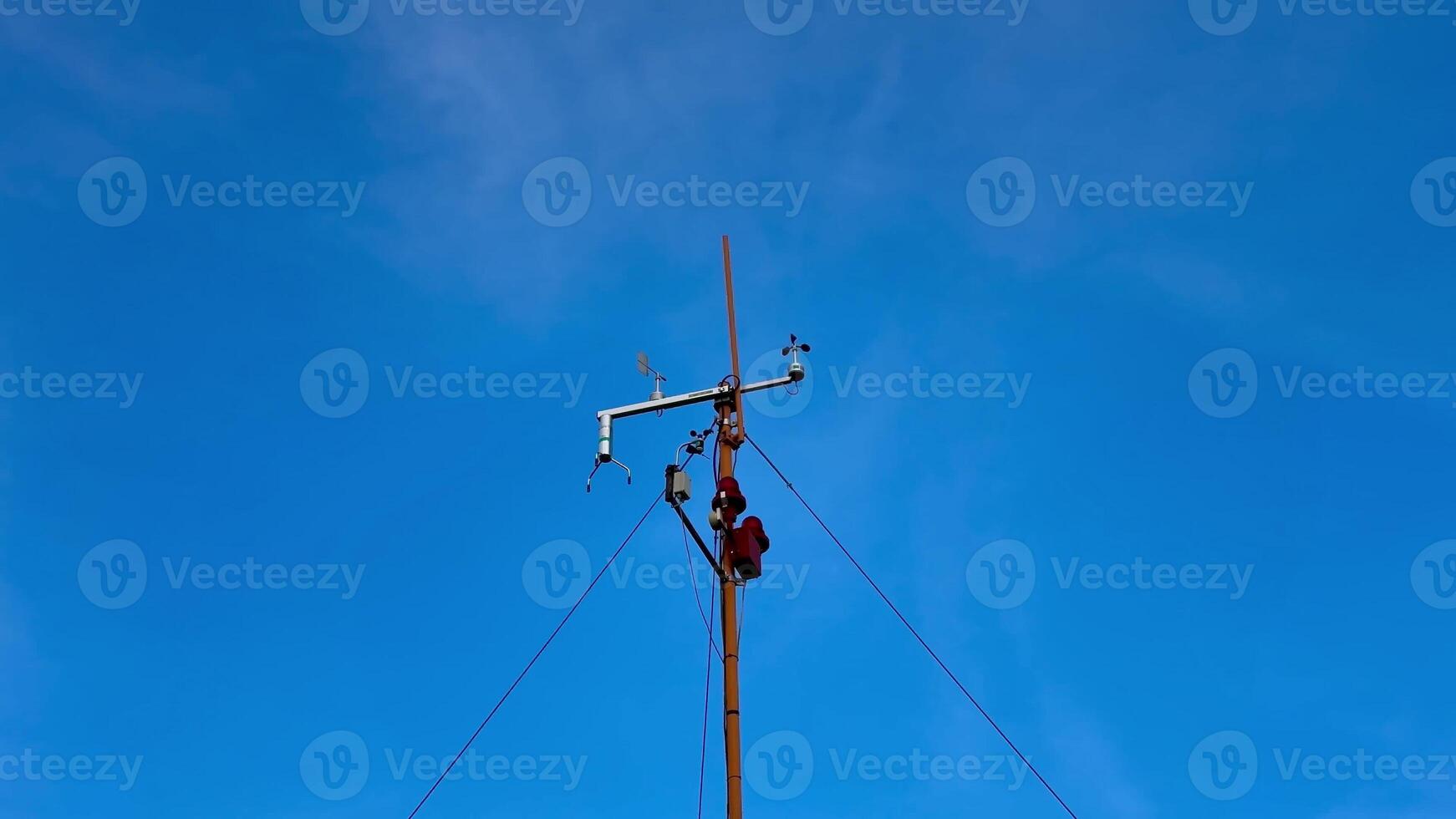 A highly skilled technician performs essential maintenance work on a utility pole against a bright blue sky photo
