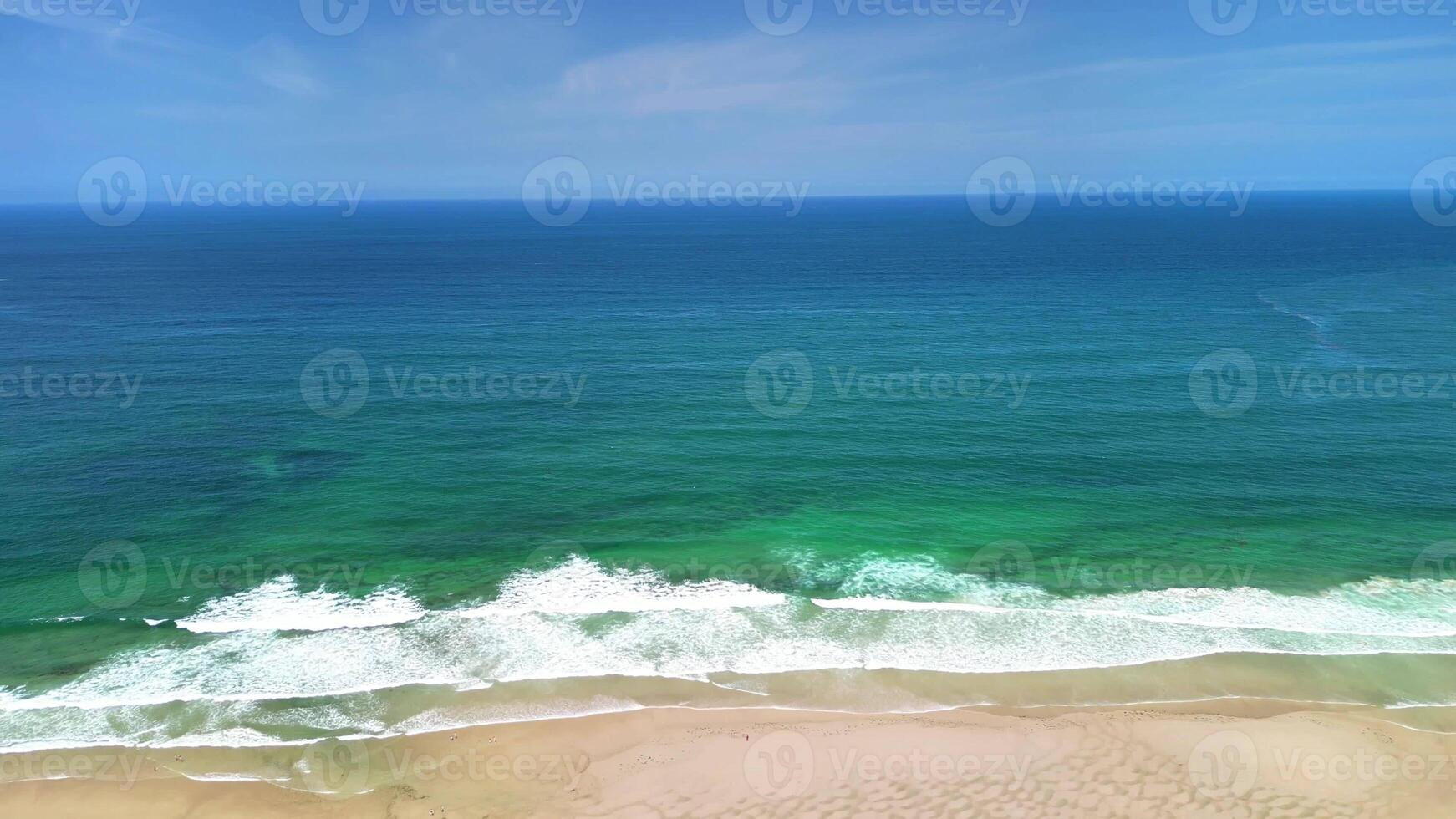 A beautifully tranquil beach scene showcasing stunning turquoise waters and soft gentle waves beneath a clear blue sky photo