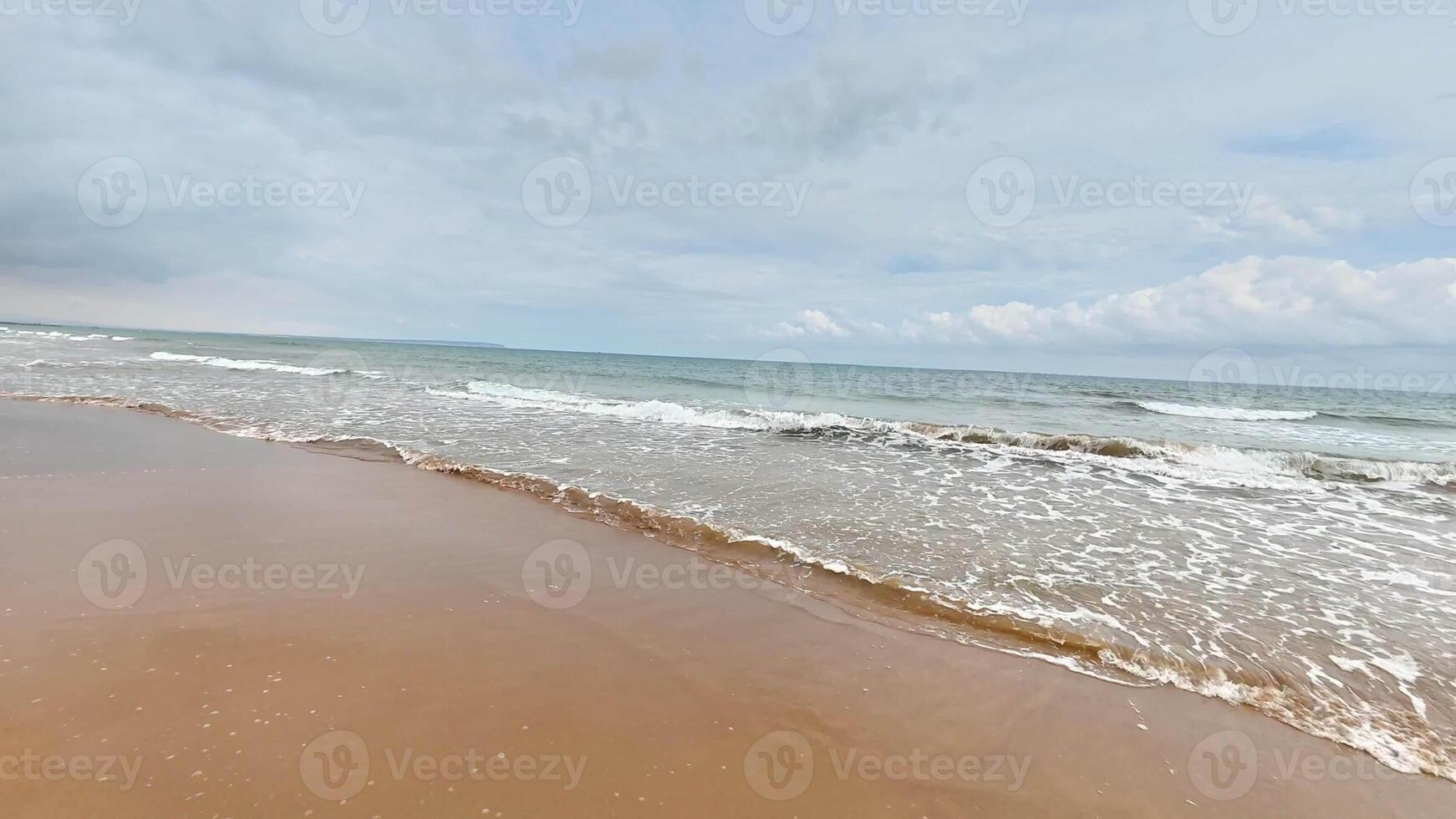 A tranquil and picturesque beach scene showcasing gentle waves gracefully lapping against the soft, golden sand photo