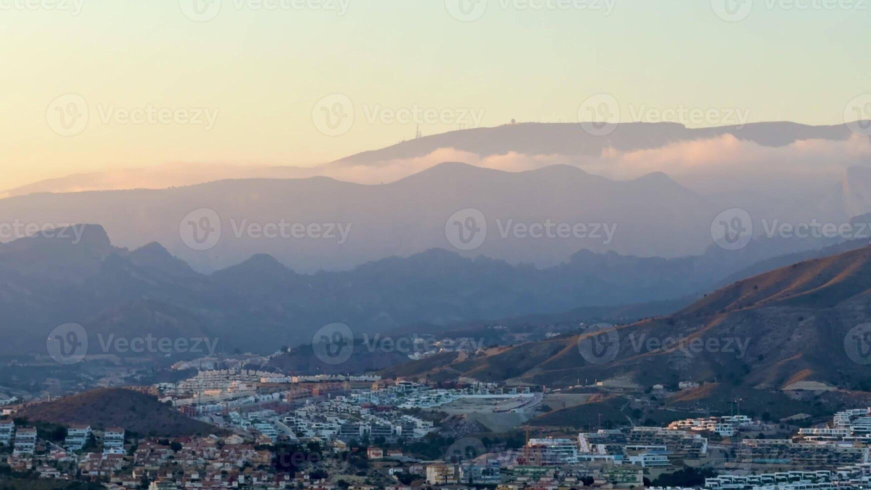 This is a breathtaking view of rolling mountains and fluffy clouds at sunset, showcasing the beauty of nature photo