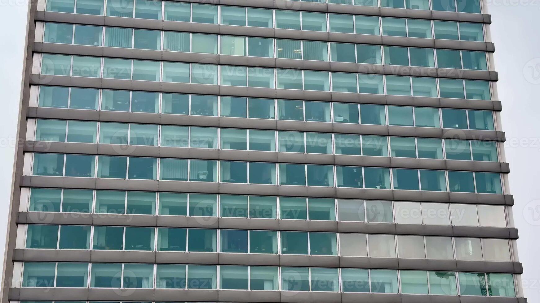 This contemporary office building features a striking, sleek glass exterior with multiple designed floors that impress photo