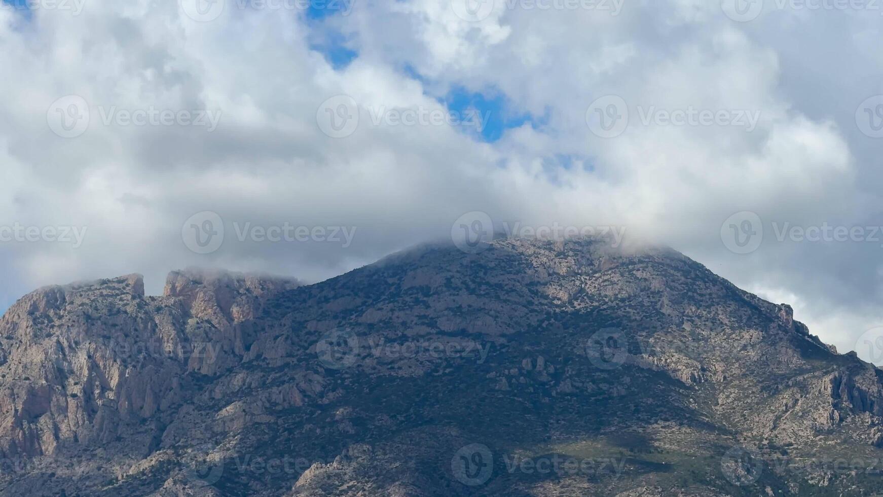 A breathtaking mountain landscape beautifully showcasing its grandeur beneath a dynamic and everchanging sky photo