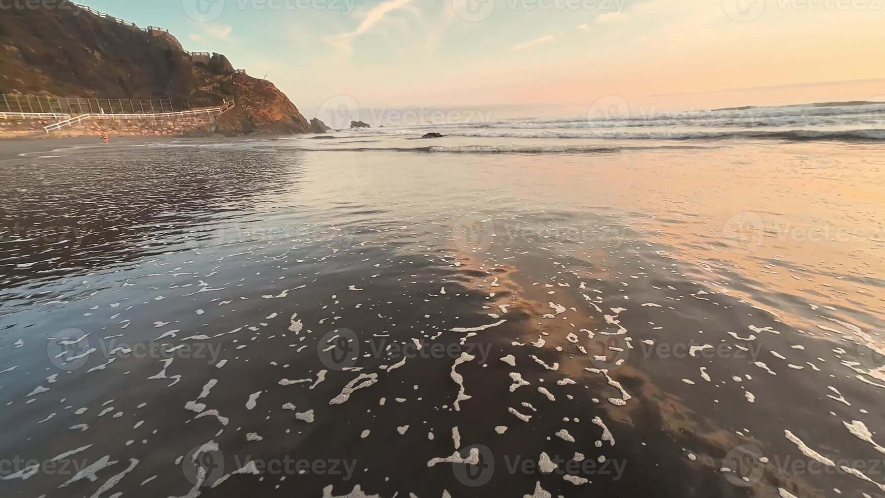 A beautifully serene view of gentle ocean waves gracefully rolling in under a spectacular colorful sunset sky photo