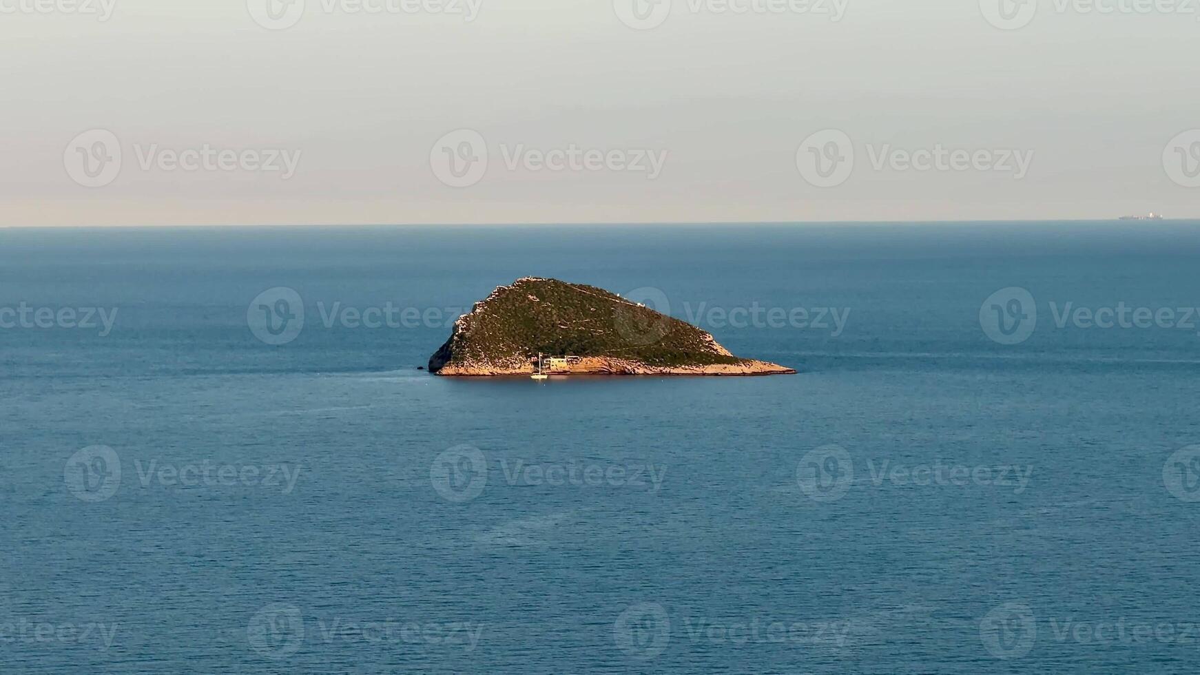 An enchanting and picturesque island, surrounded by tranquil and serene waters, captures an idyllic coastal scene photo