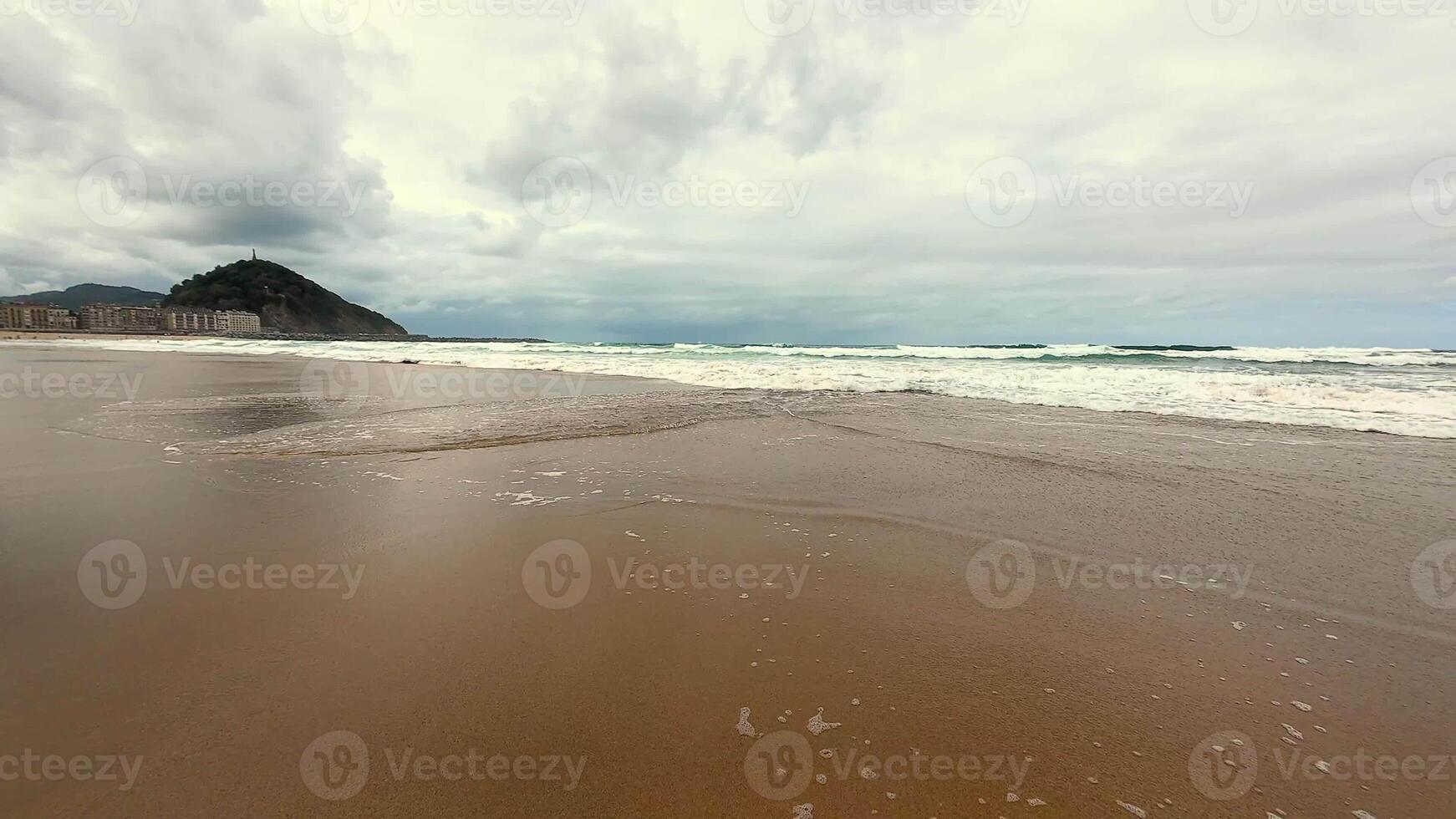A tranquil and serene beach with soft, gentle waves and an overcast sky, perfect for relaxation and peaceful escape photo