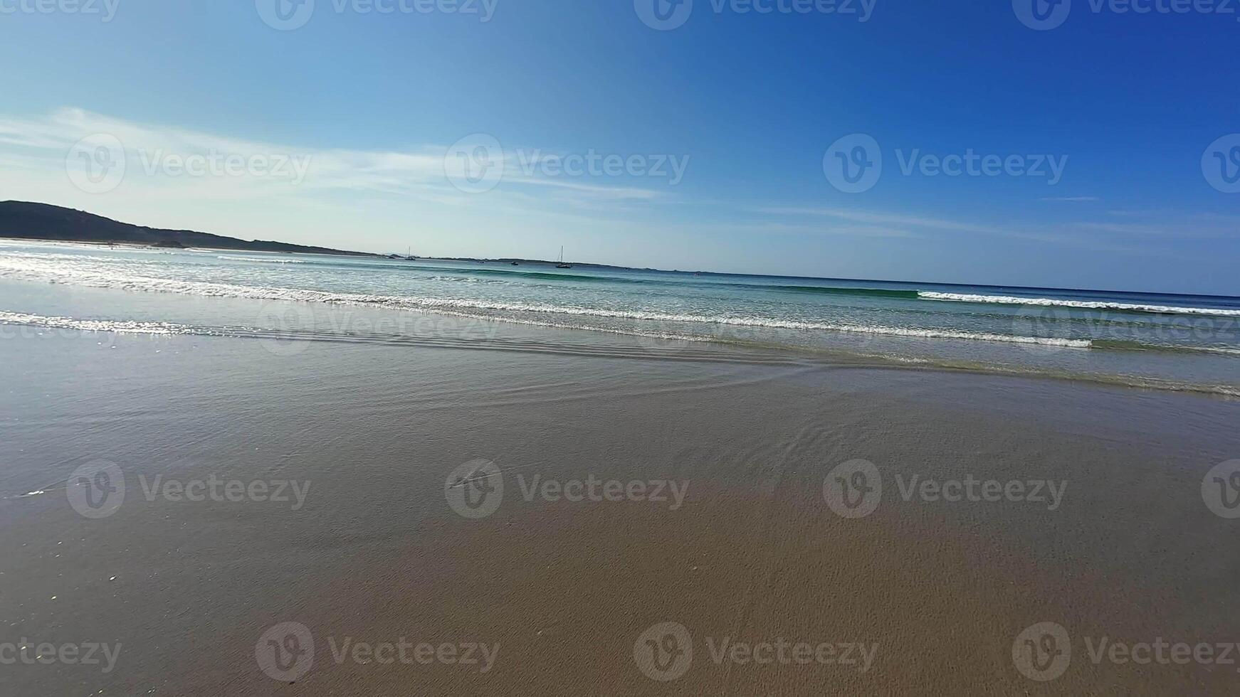 Imagine a serene beach with soothing waves and a bright blue sky, perfect for complete relaxation and unwinding photo