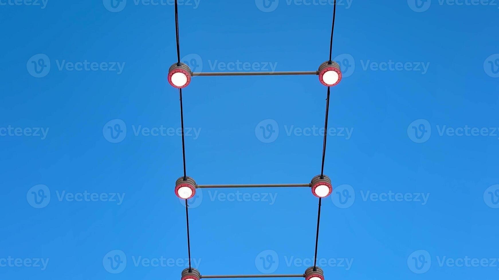 A mesmerizing display of red lights framed by clear blue sky, perfect for modern design inspiration. photo