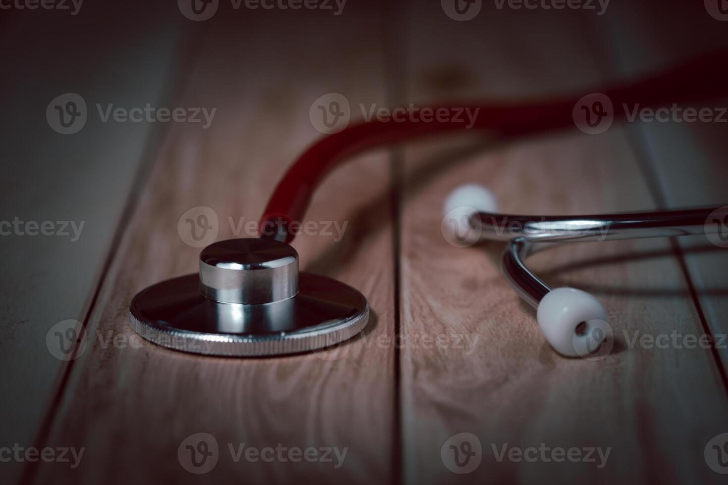Red Tubed Stethoscope on Wood, Symbolizing Healthcare, Diagnostics, and Medical Expertise photo